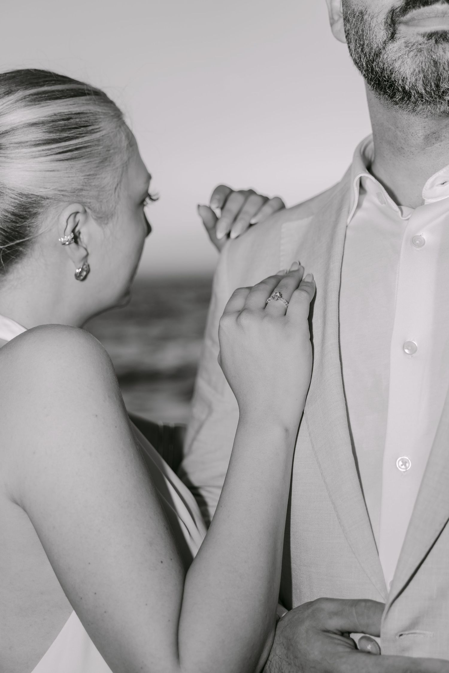 Black and white close-up of a couple holding hands during a portrait session.