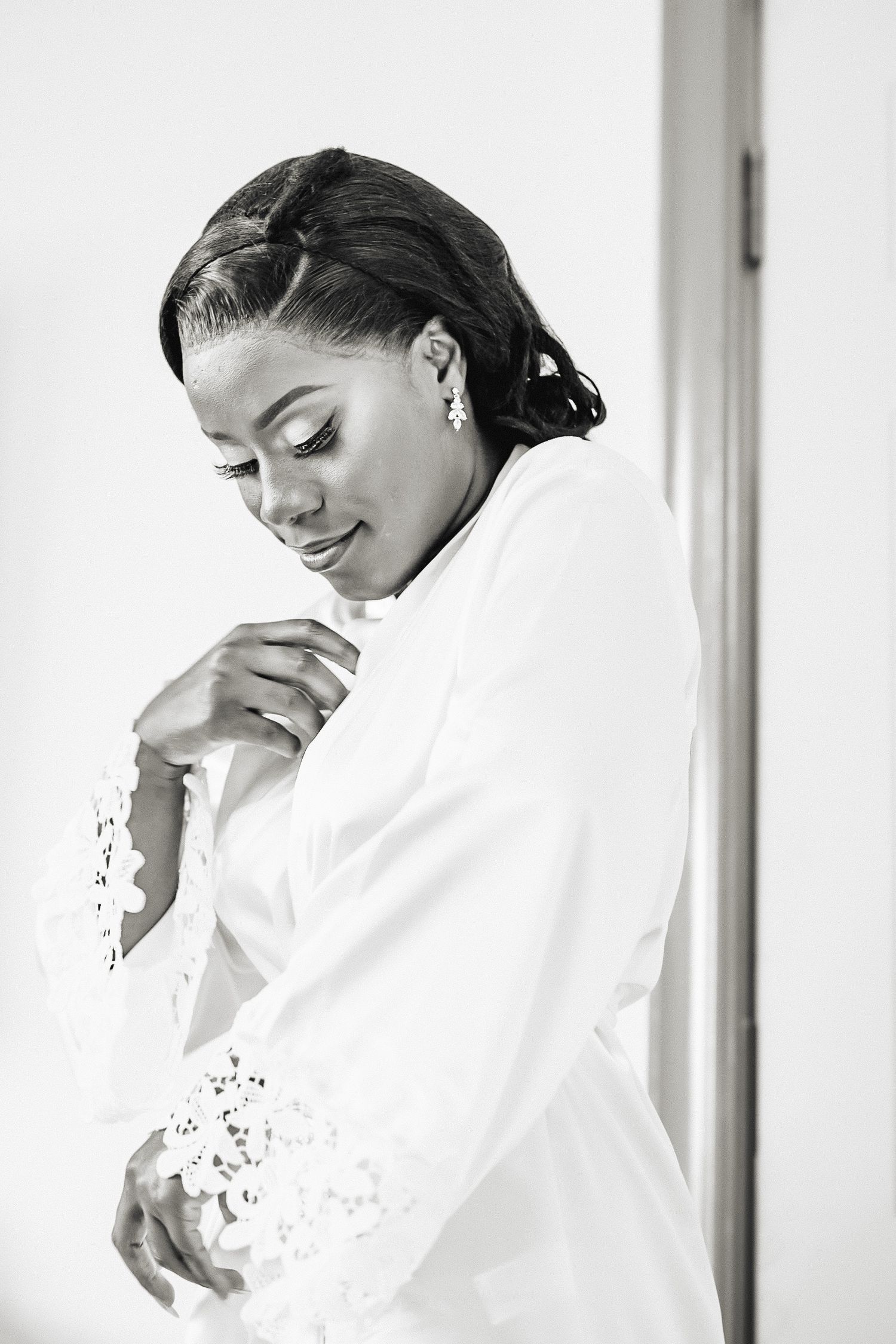 Elegant bridal preparation moments captured in soft black and white photography.