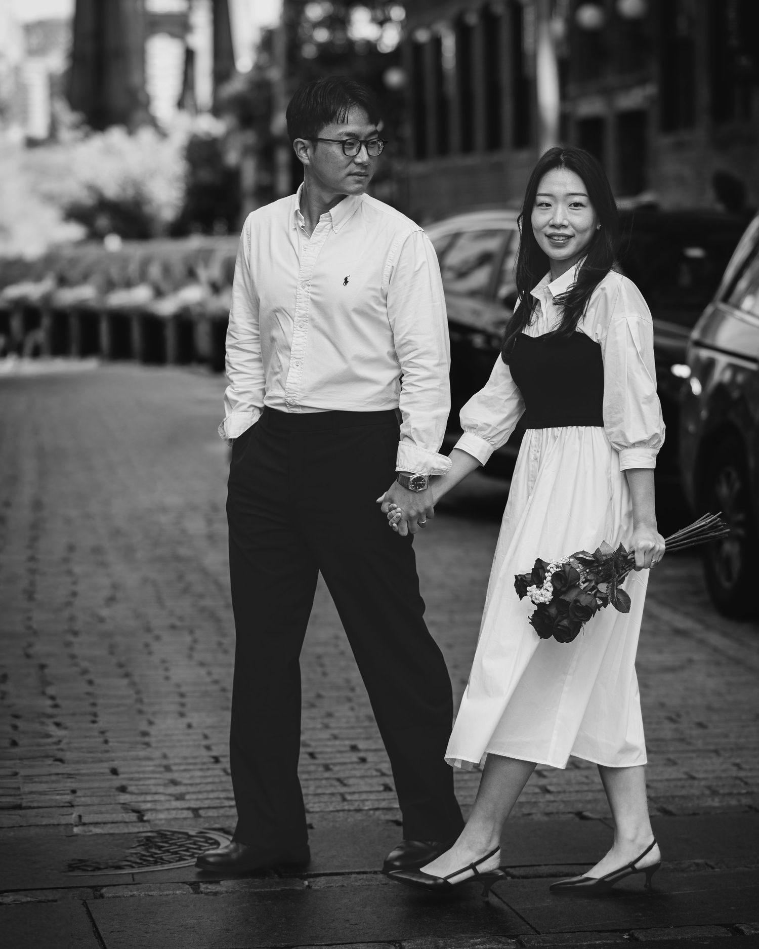 Black and white portrait series capturing tender moments on a cobblestone street.