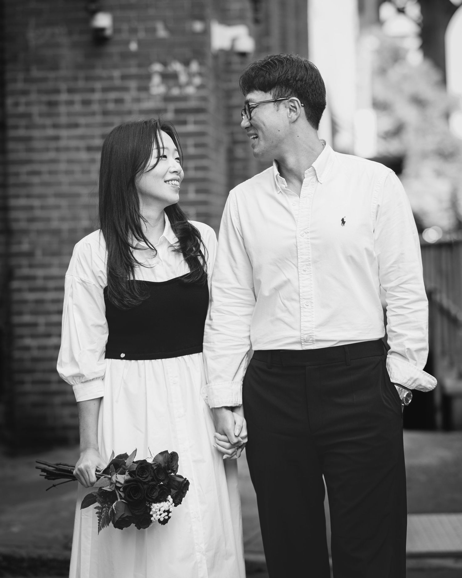 Couple in contrasting black and white outfits share intimate moments in an urban setting.