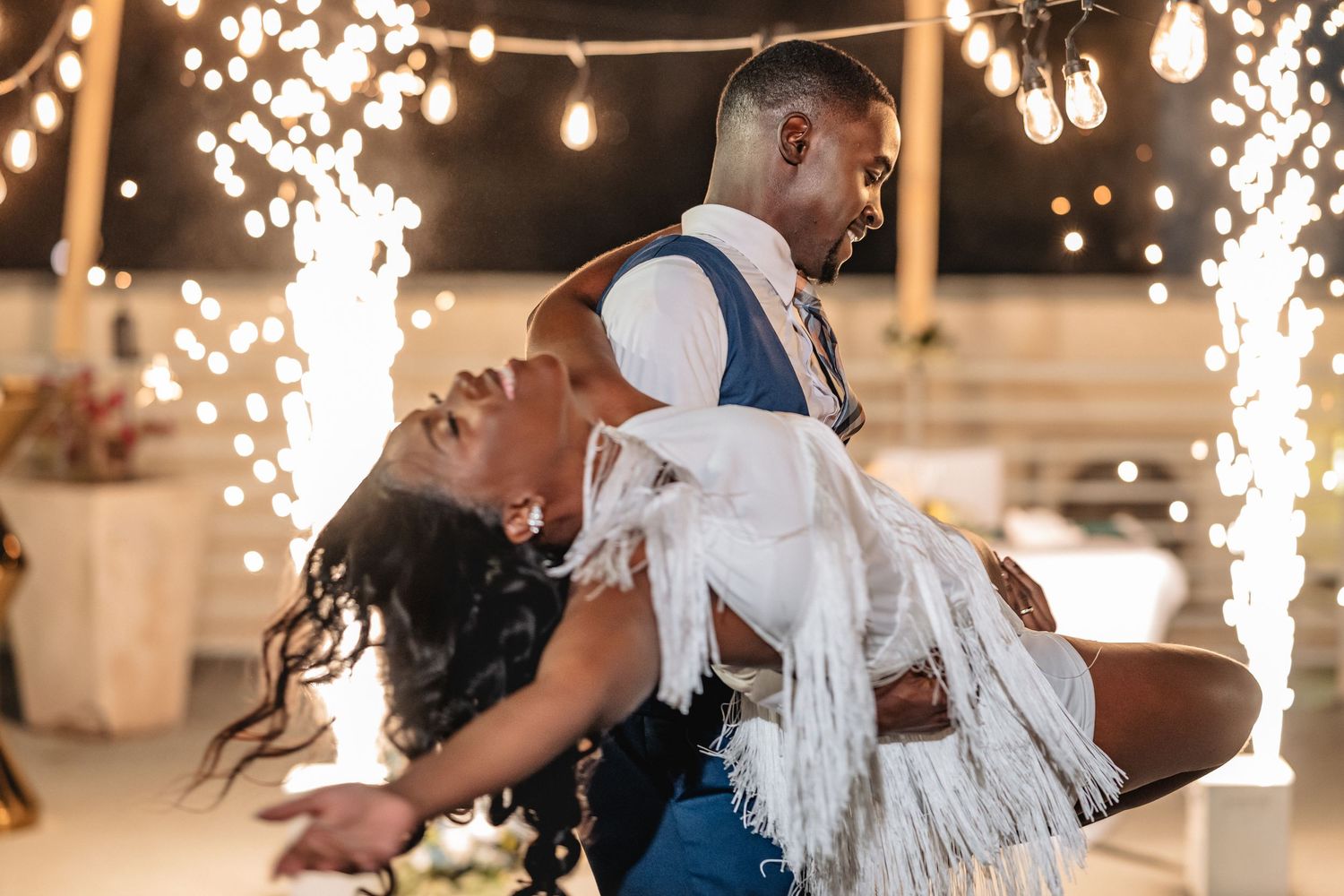 Wedding celebration with sparkler effects and string lights creating dramatic nighttime ambiance.