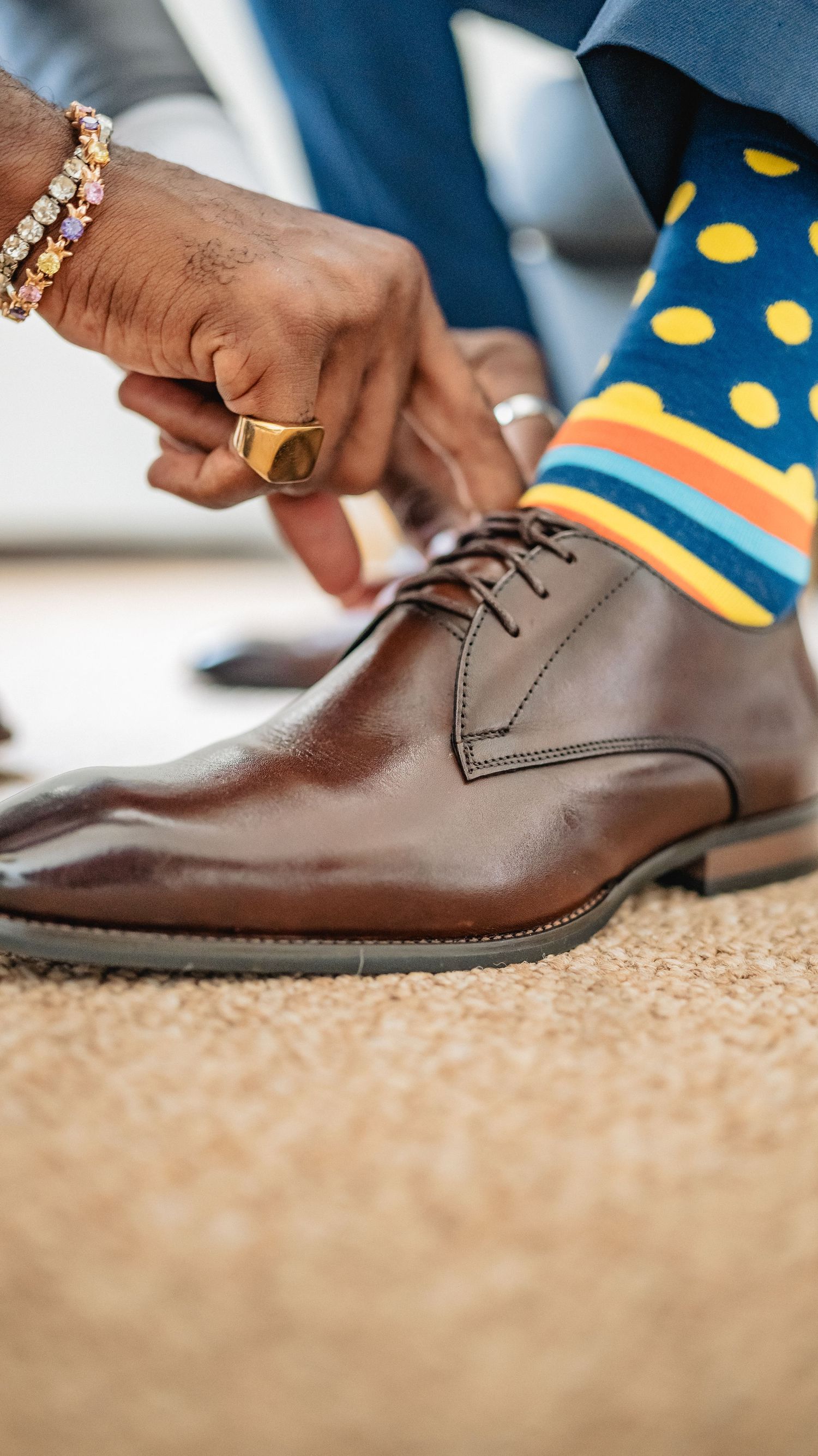 Brown leather dress shoes with polka dot socks shown in detail shot.