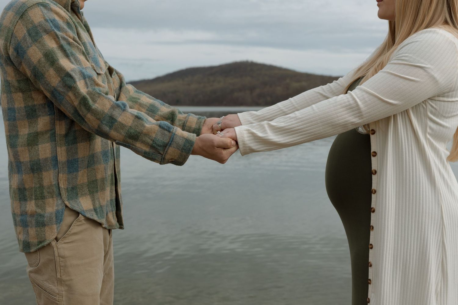 husband and wife holding hands with mountain in the background, maternity