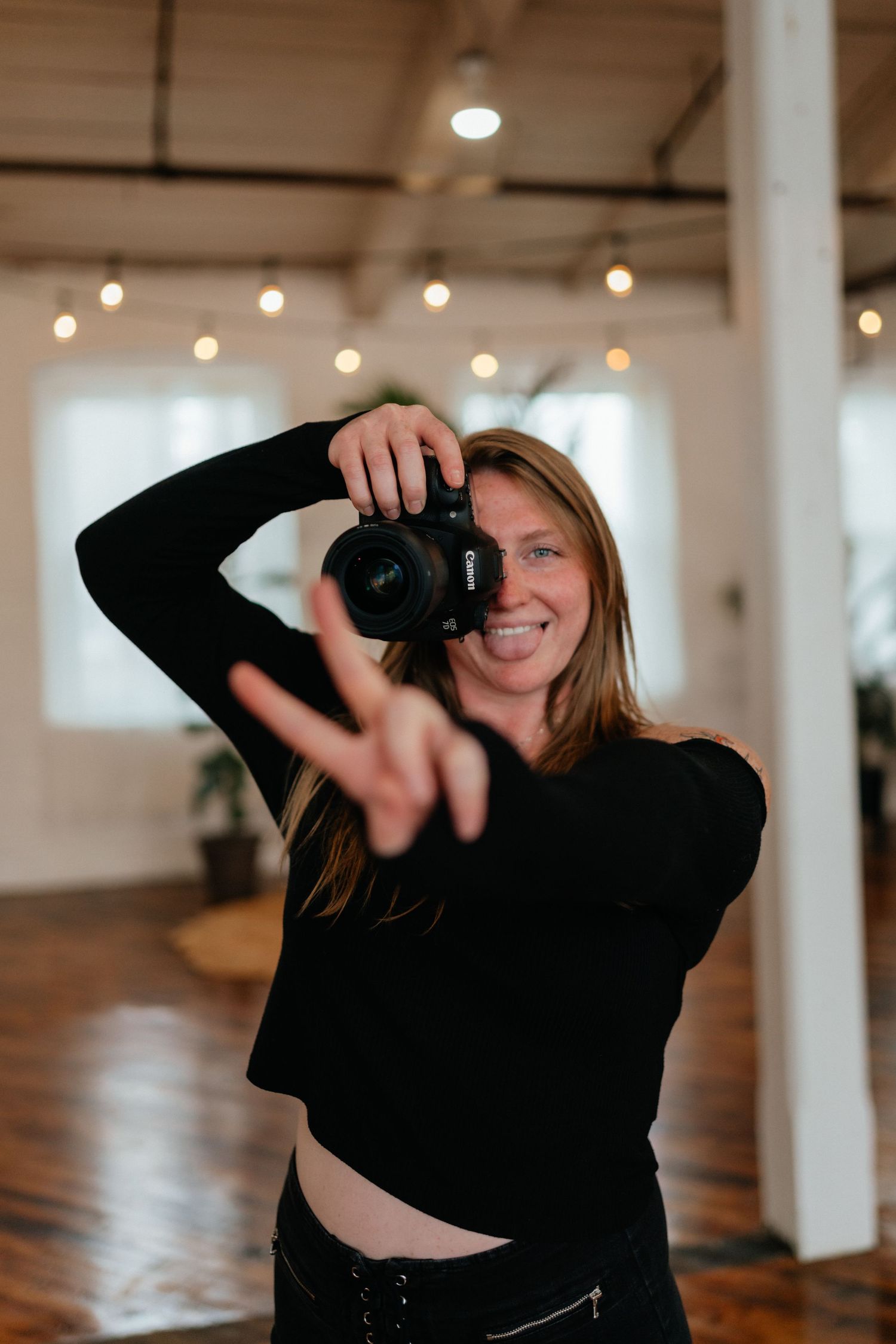 girl holding holding camera and peace sign