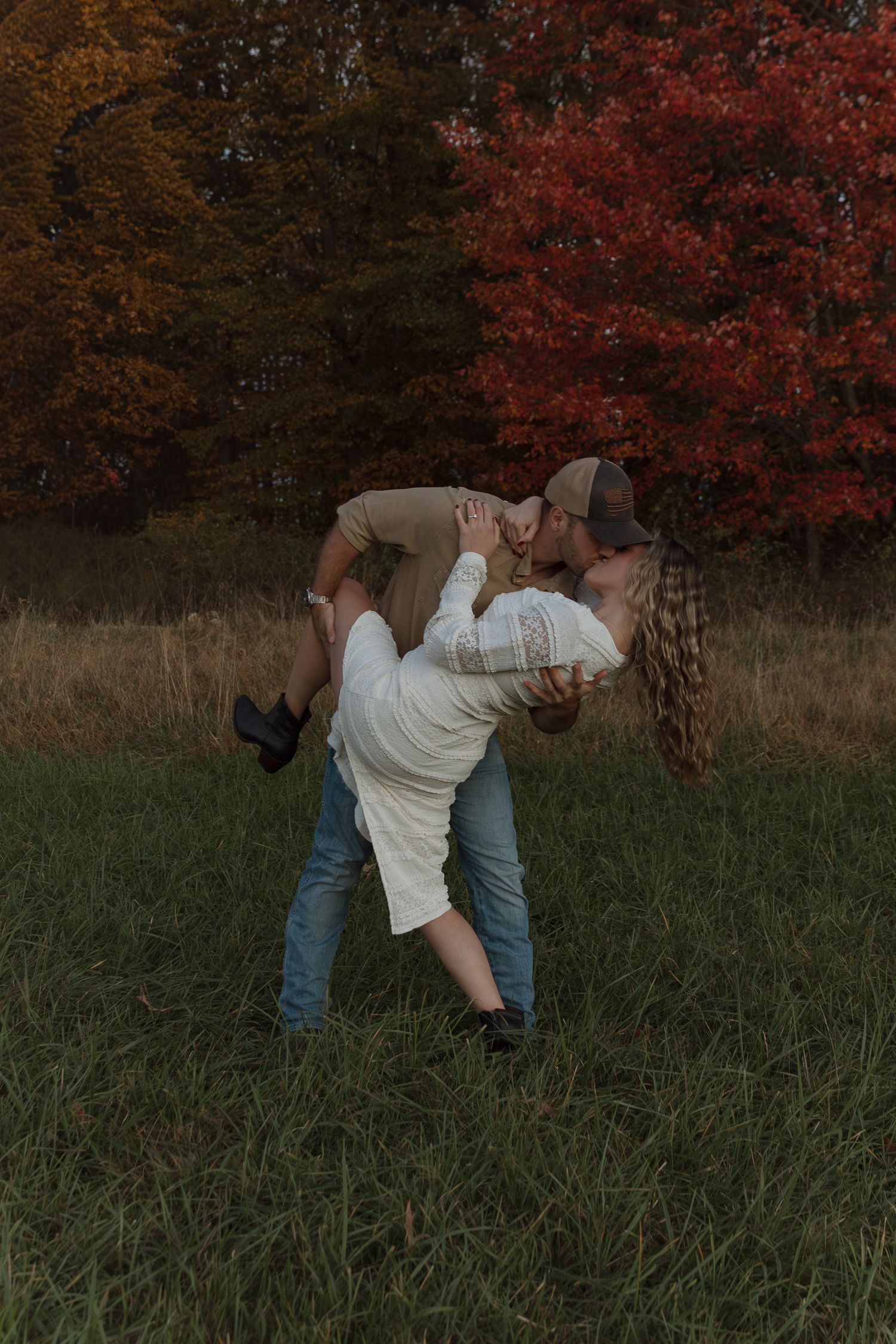 couple dip kiss under fall foliage, engagement session