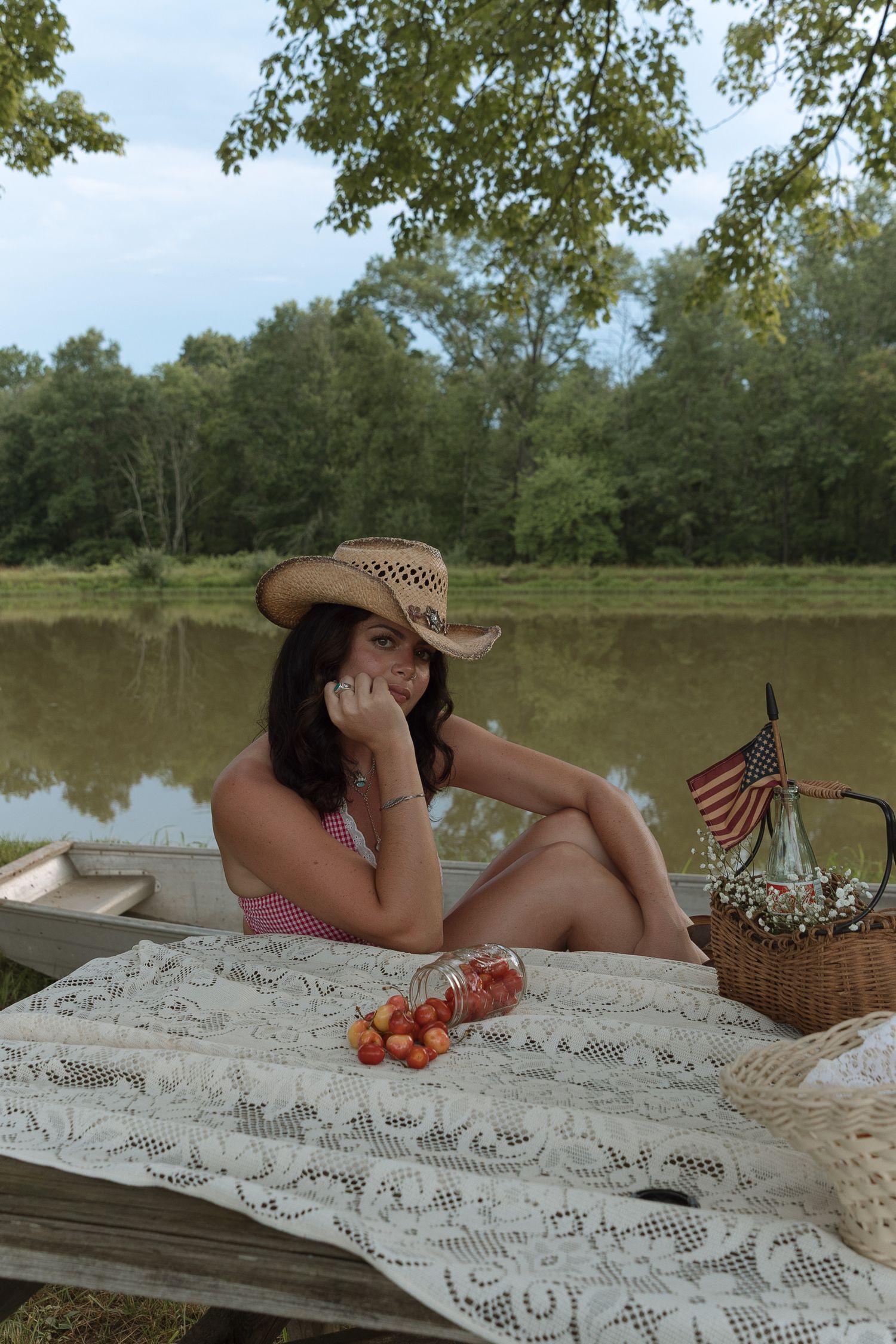 young lady sitting at picnic table by a pond, Americana