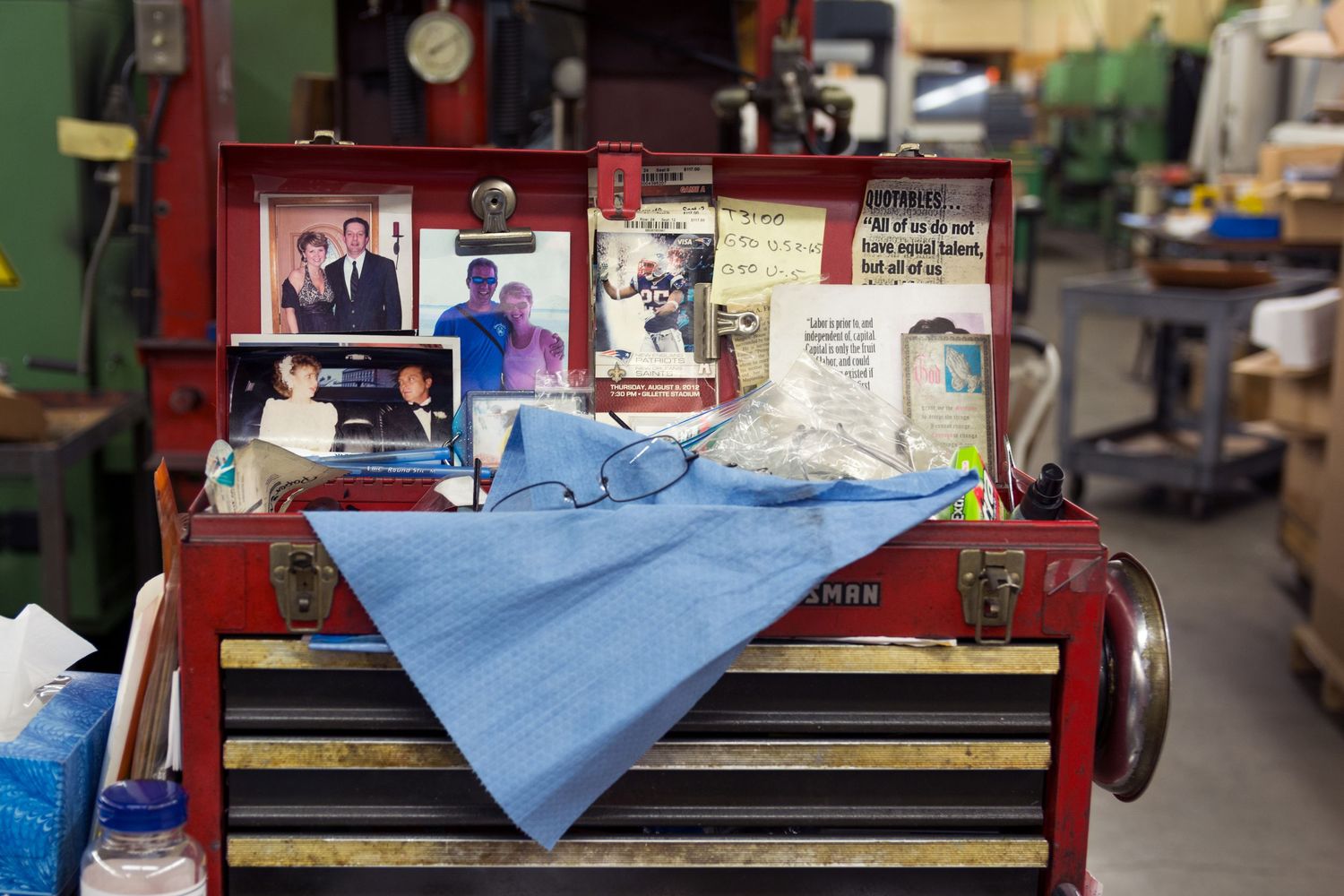 Industrial workspace with workbenches and equipment arranged along a wall.