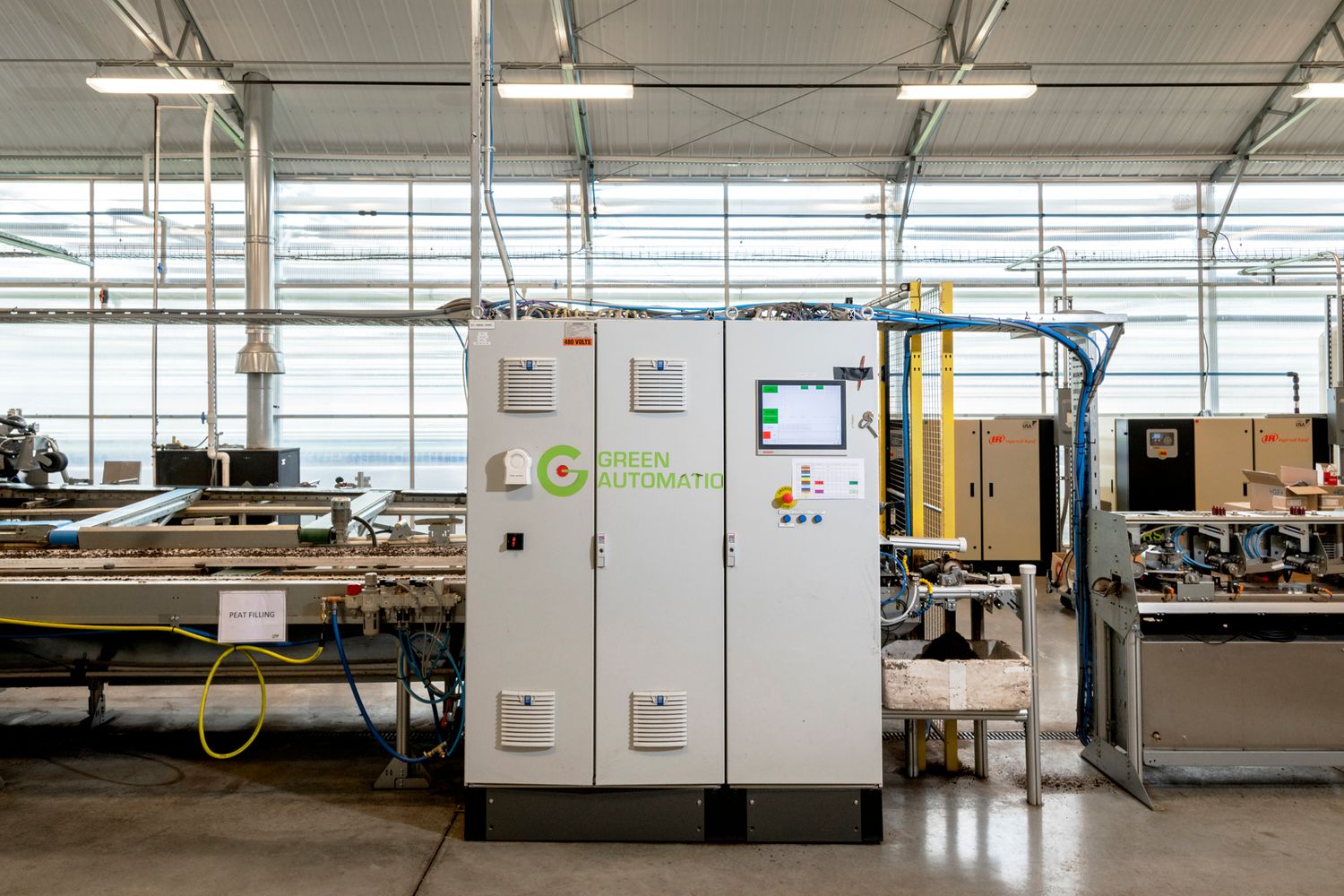 Clean, modern indoor agriculture facility with automated equipment and natural lighting.