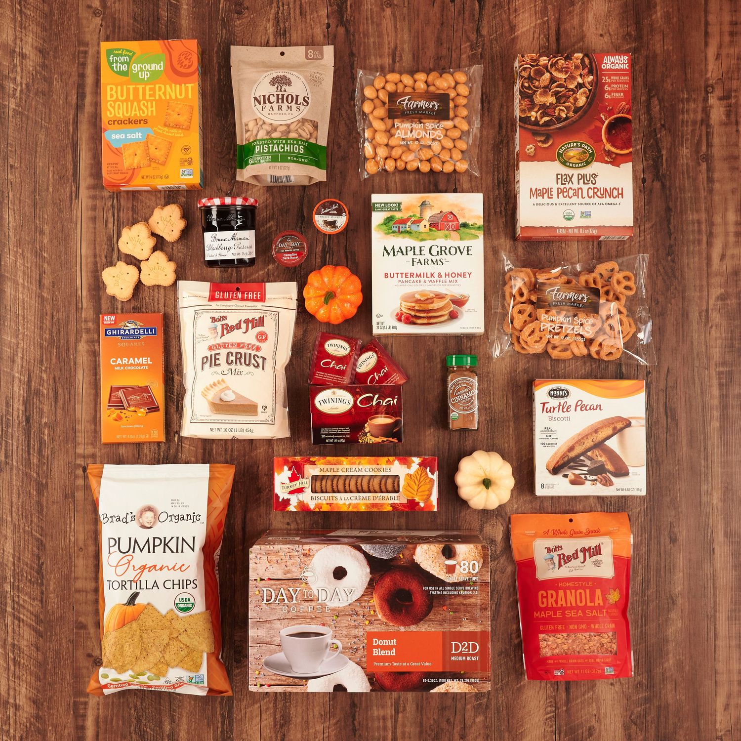 Assorted fall snacks and pantry items flatlay including granola, pretzels, tortilla chips, pancake mix, and seasonal treats.