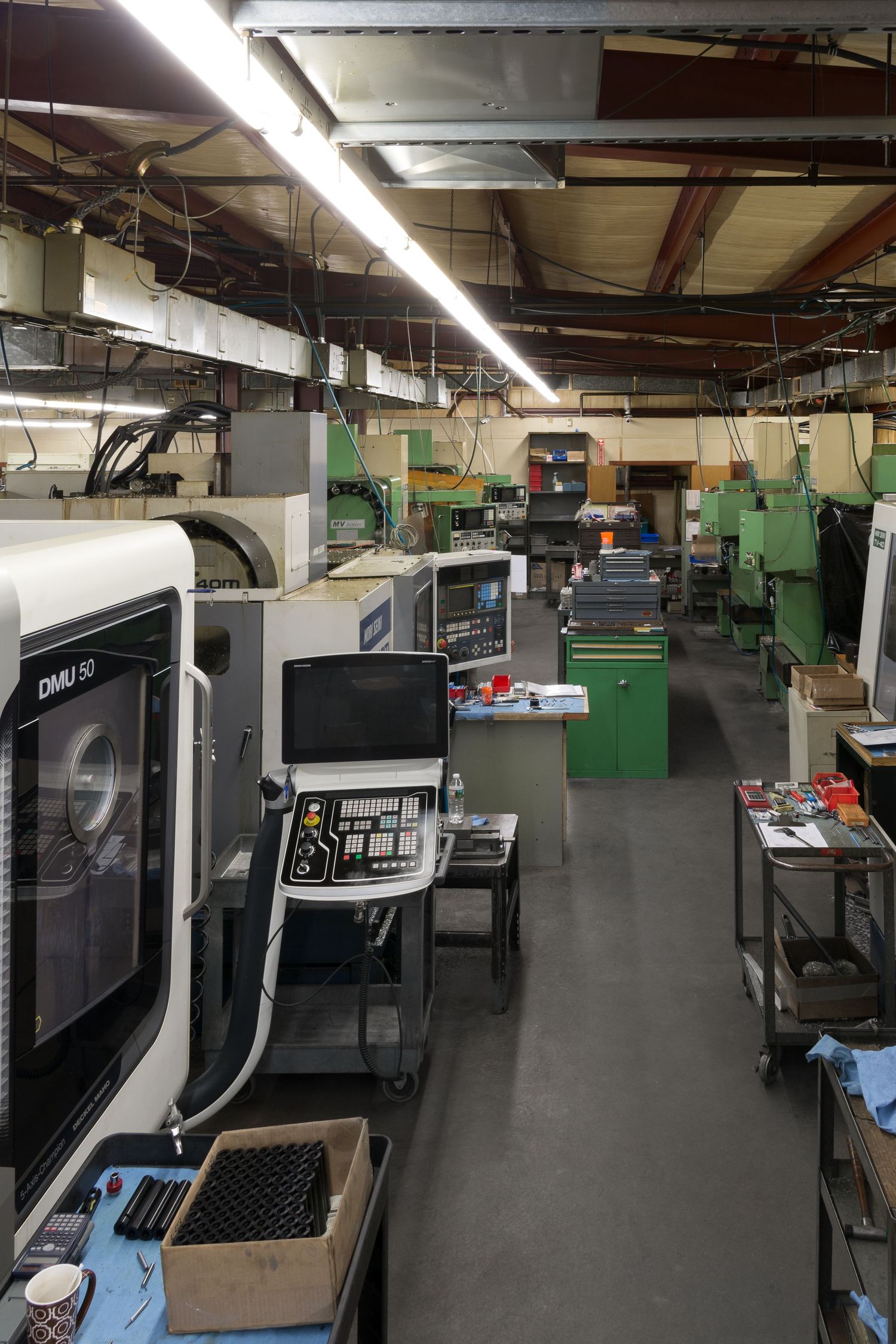 Modern manufacturing facility interior with CNC machines and equipment in a clean workspace.