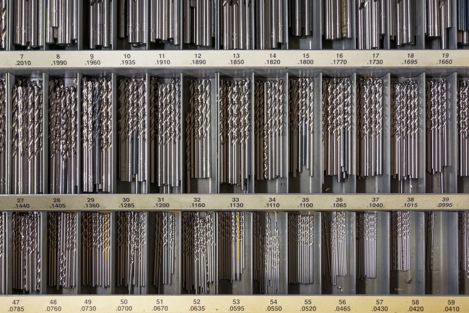 Row of industrial metal rods and components arranged in sequence.