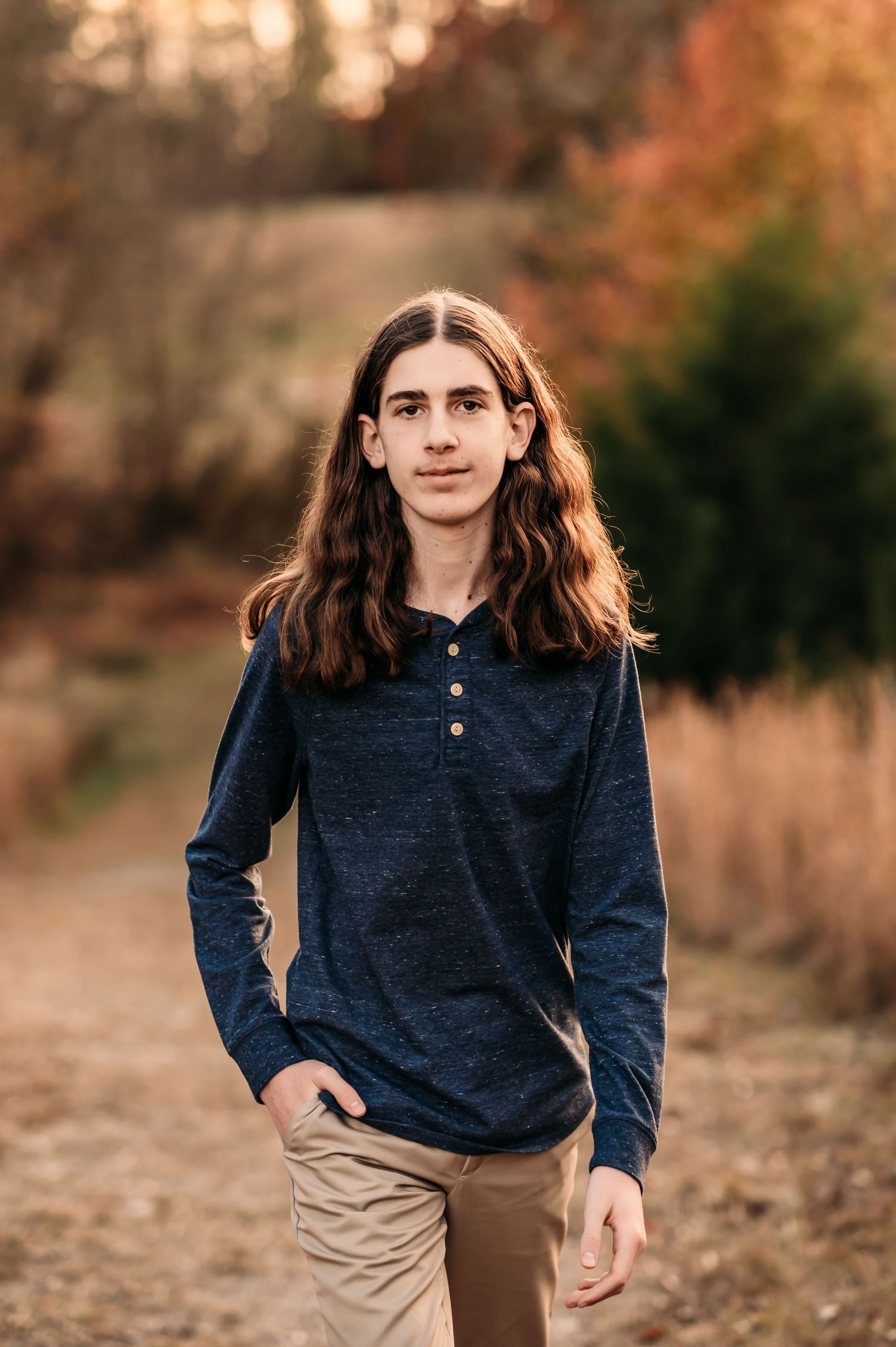 Teenage boy walking on a Fall path in a park.
