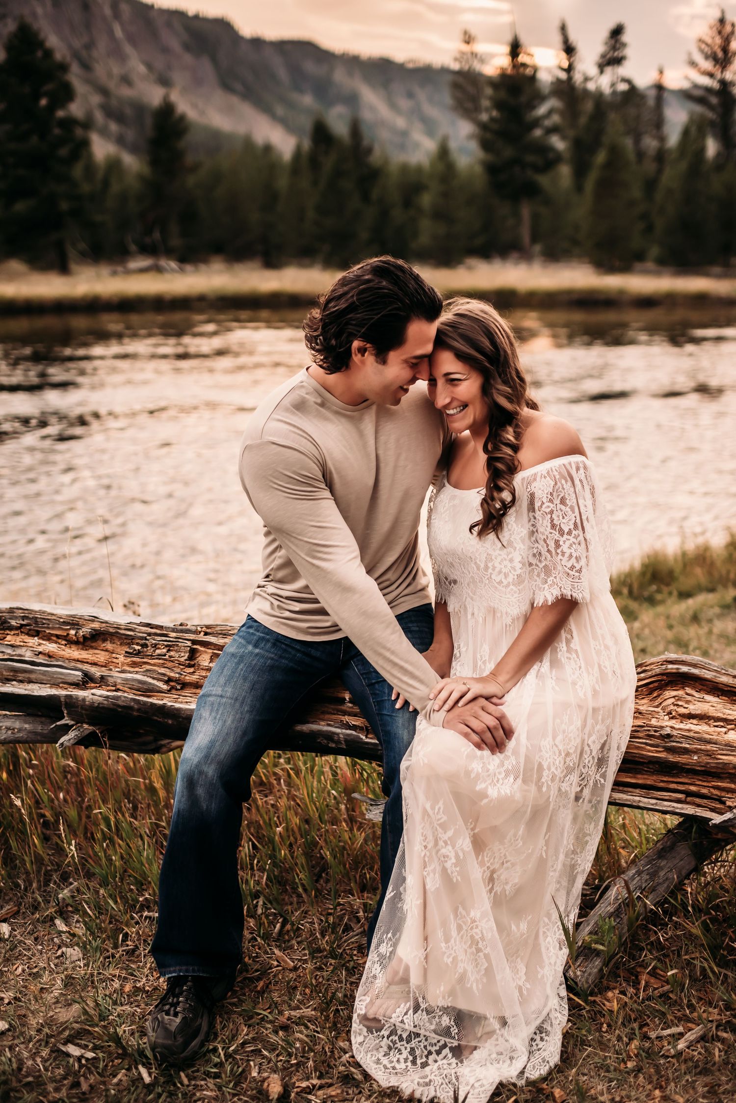 Couple laughing together with lake and mountainous views behind them.