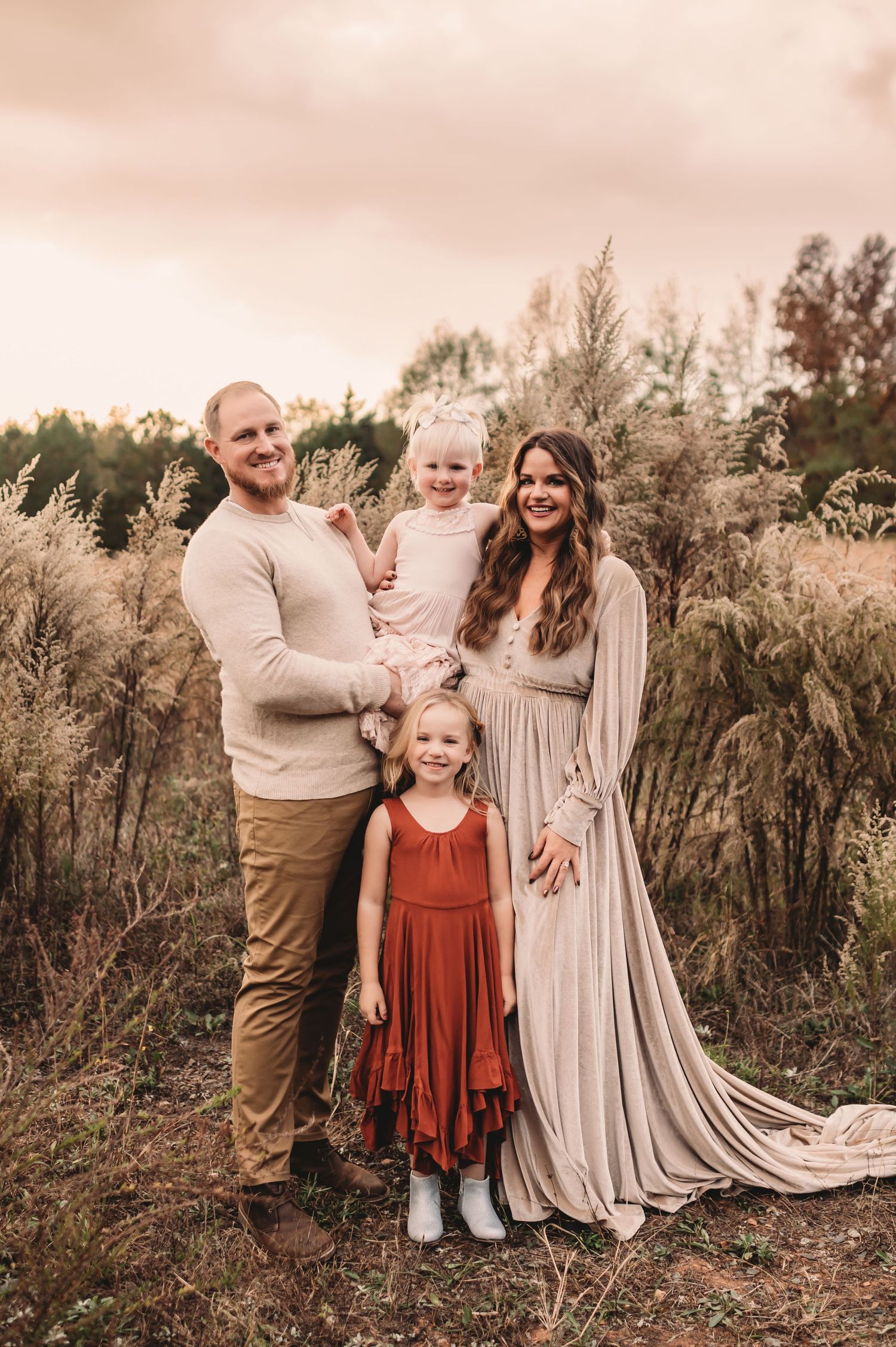 Family of four portrait in a tall grass field capturing by Fallon Photography in Charlotte, North Carolina.