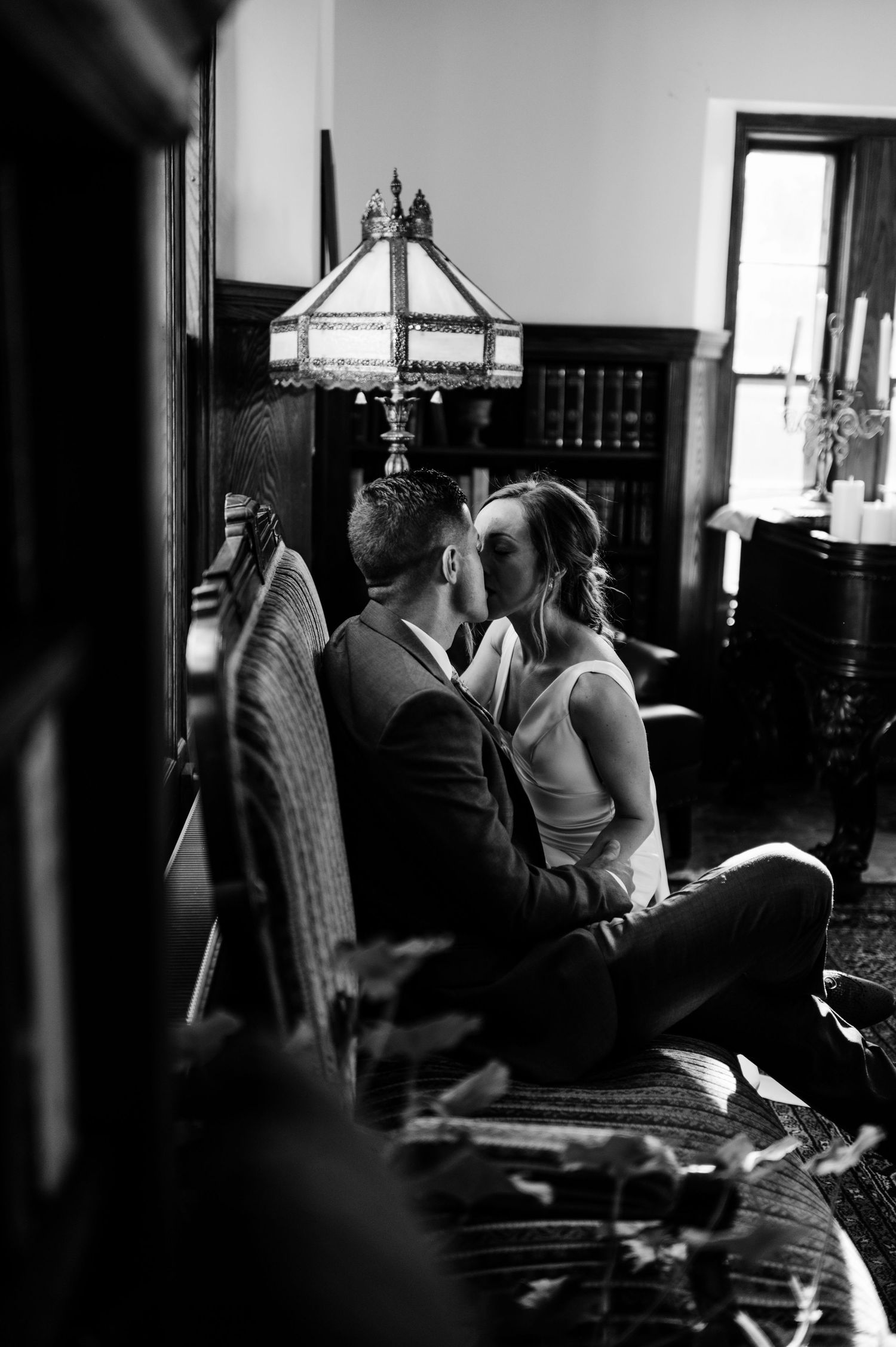 Two people sit close together at a piano in a dimly lit room creating an intimate musical moment.