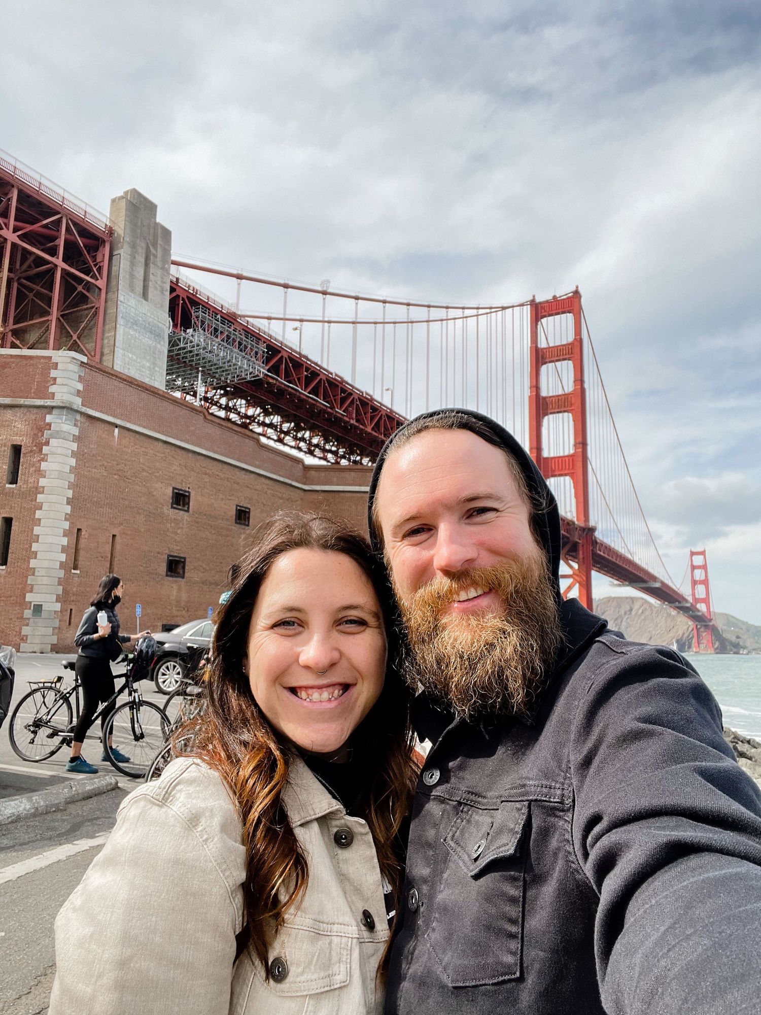 Cyclists and pedestrians enjoy views of the iconic Golden Gate Bridge on a cloudy San Francisco day.