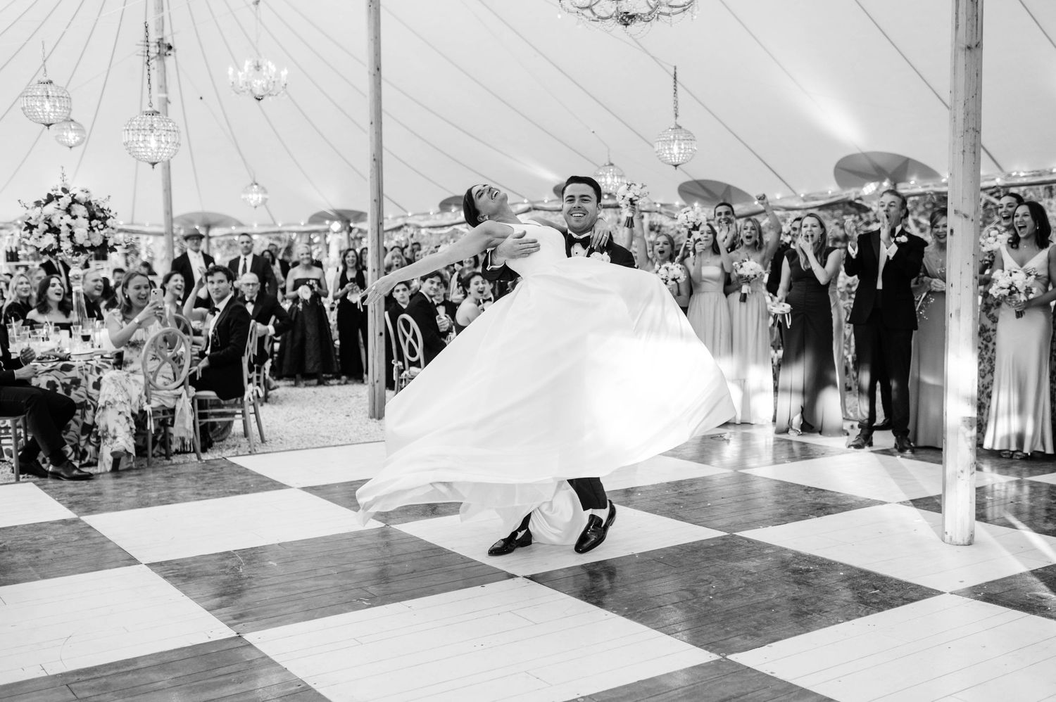 A couple performs a graceful dance with flowing white fabric during a wedding celebration as guests watch in admiration.