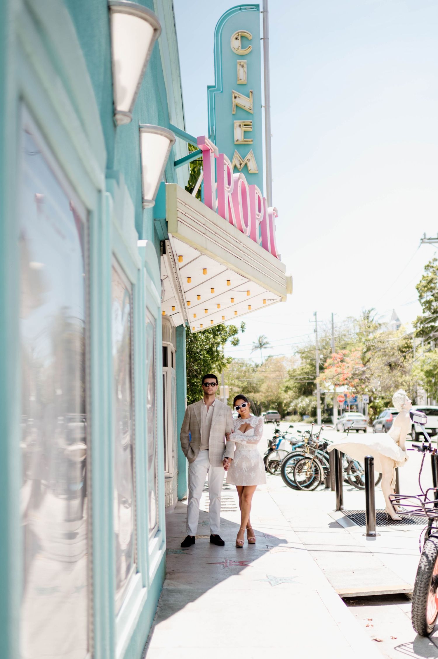 Pastel turquoise storefront with white trim and outdoor seating along a sunny sidewalk.