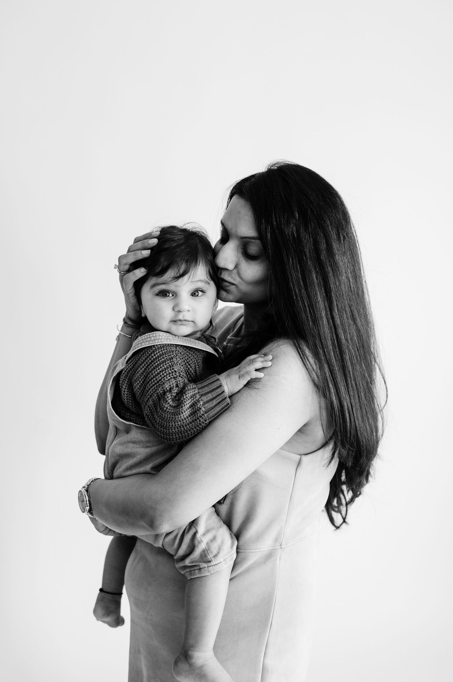 Intimate black and white portrait of tender embrace against white background.