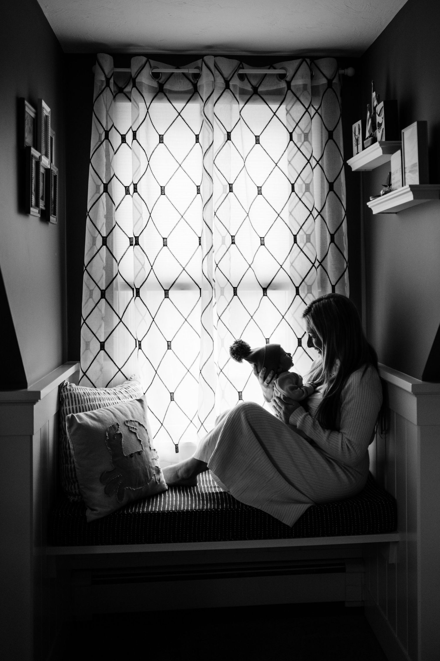 A series of black and white photos showing someone reclining in a window nook with dramatic lighting and shadows.