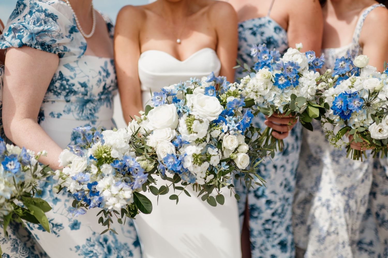 Wedding bouquets in shades of blue and white flowers arranged in a row with delicate floral details.