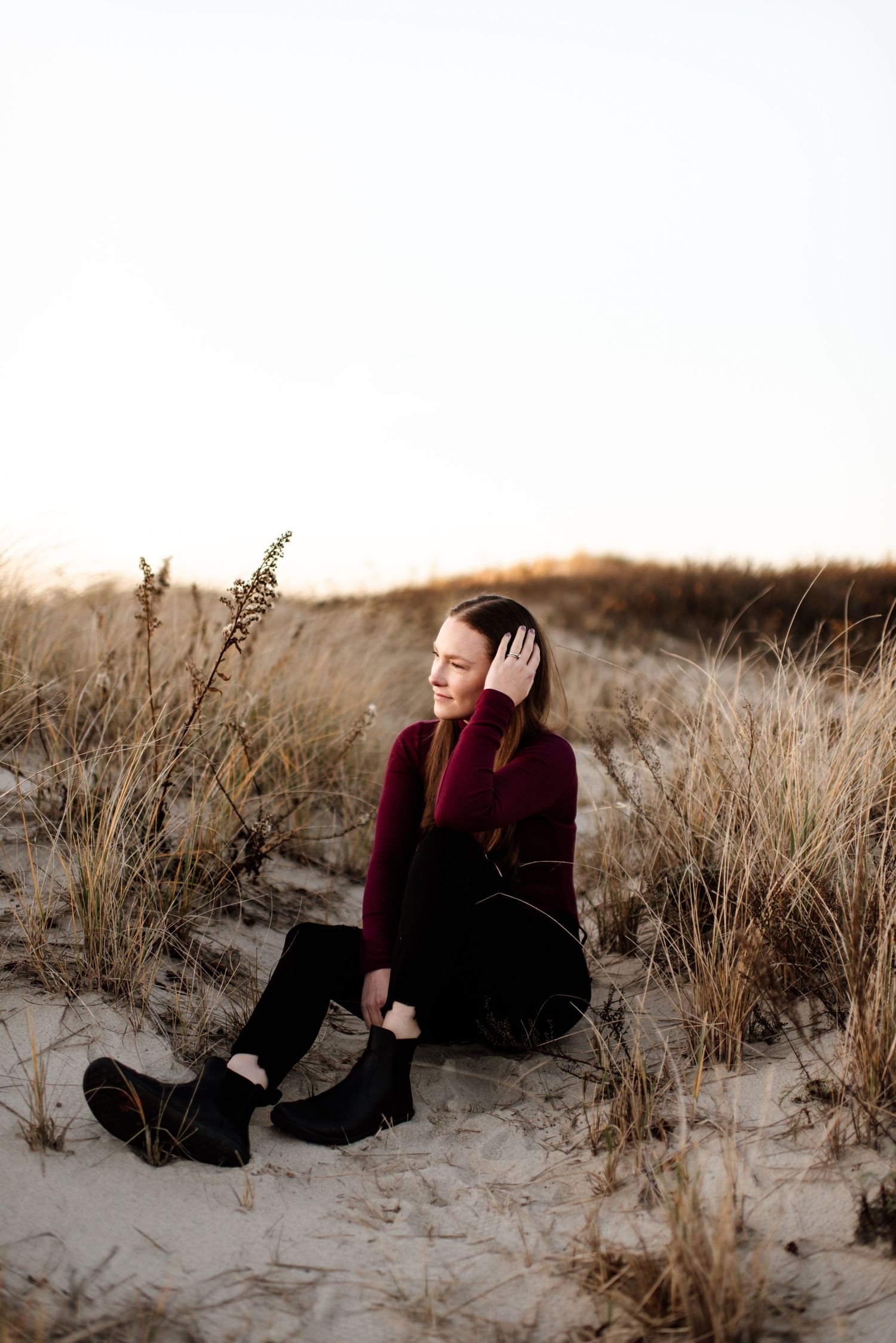 Artistic portrait series captured in sand dunes during golden hour.