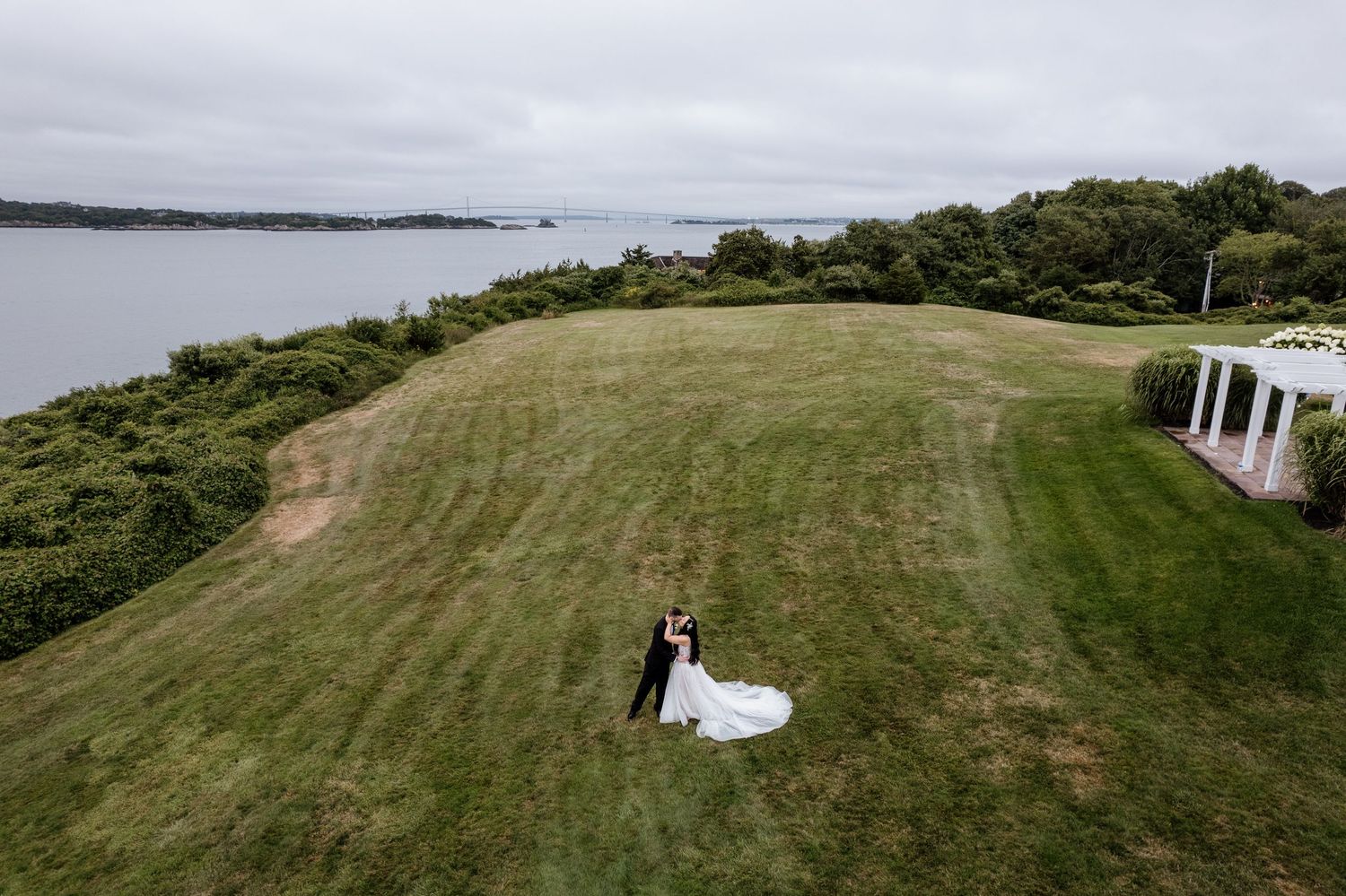 A sweeping landscape view of a coastal wedding venue with rolling green hills.