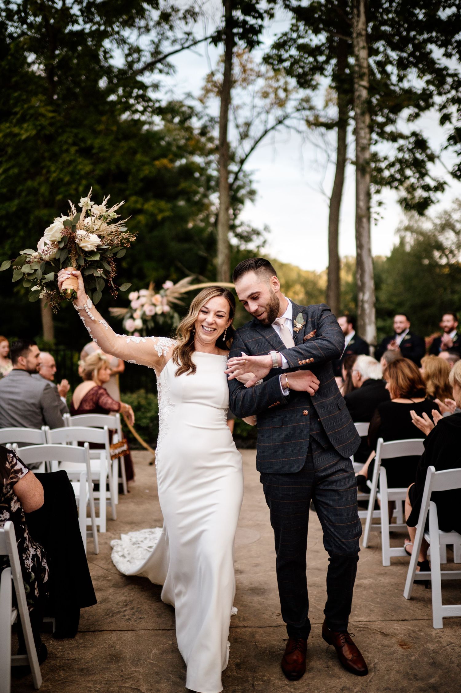 A sequence of joyful dancing moments captured at an outdoor wedding ceremony with white chairs and trees in the background.