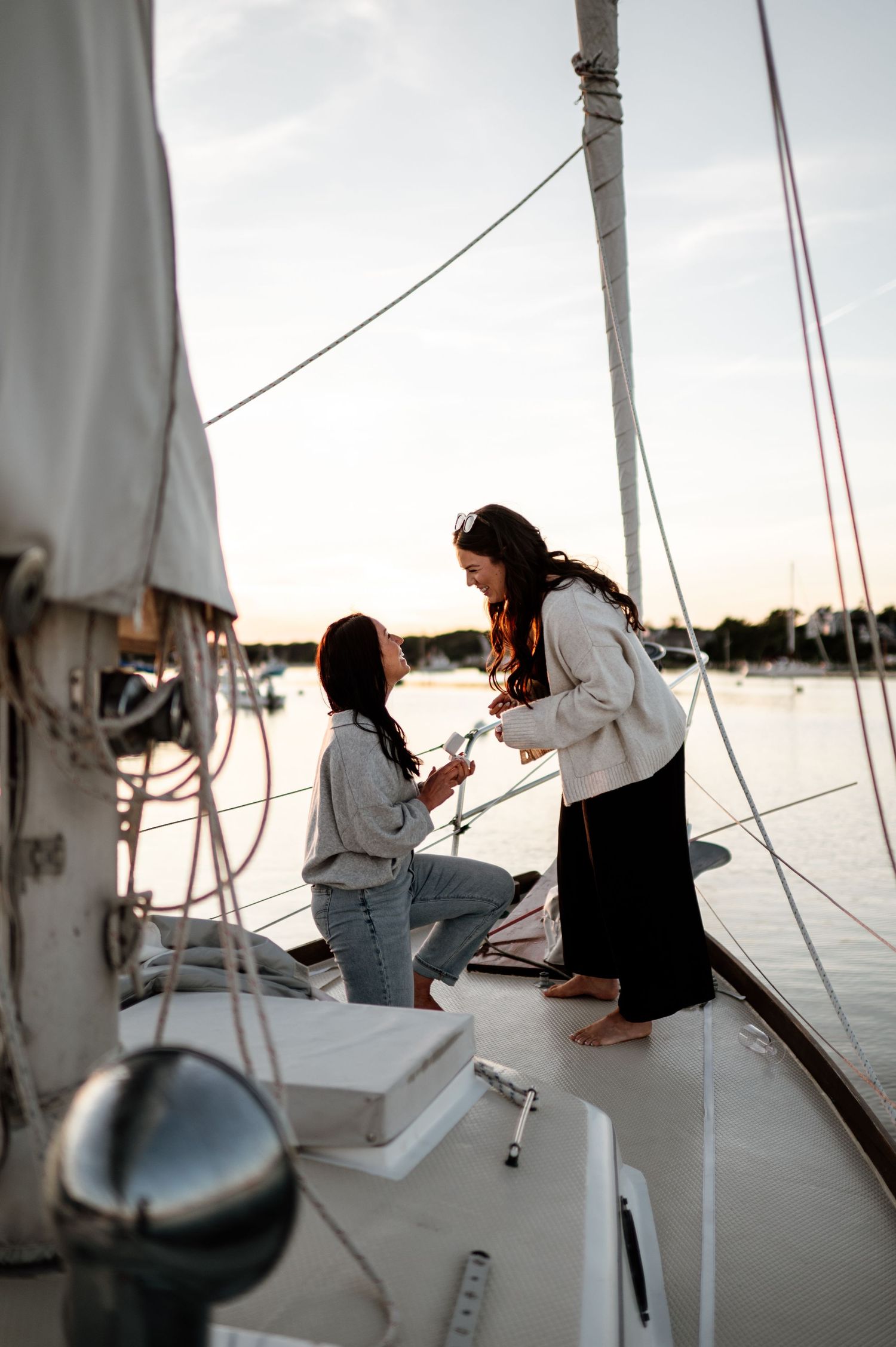 Series of casual moments aboard a sailboat during sunset with white sails visible.