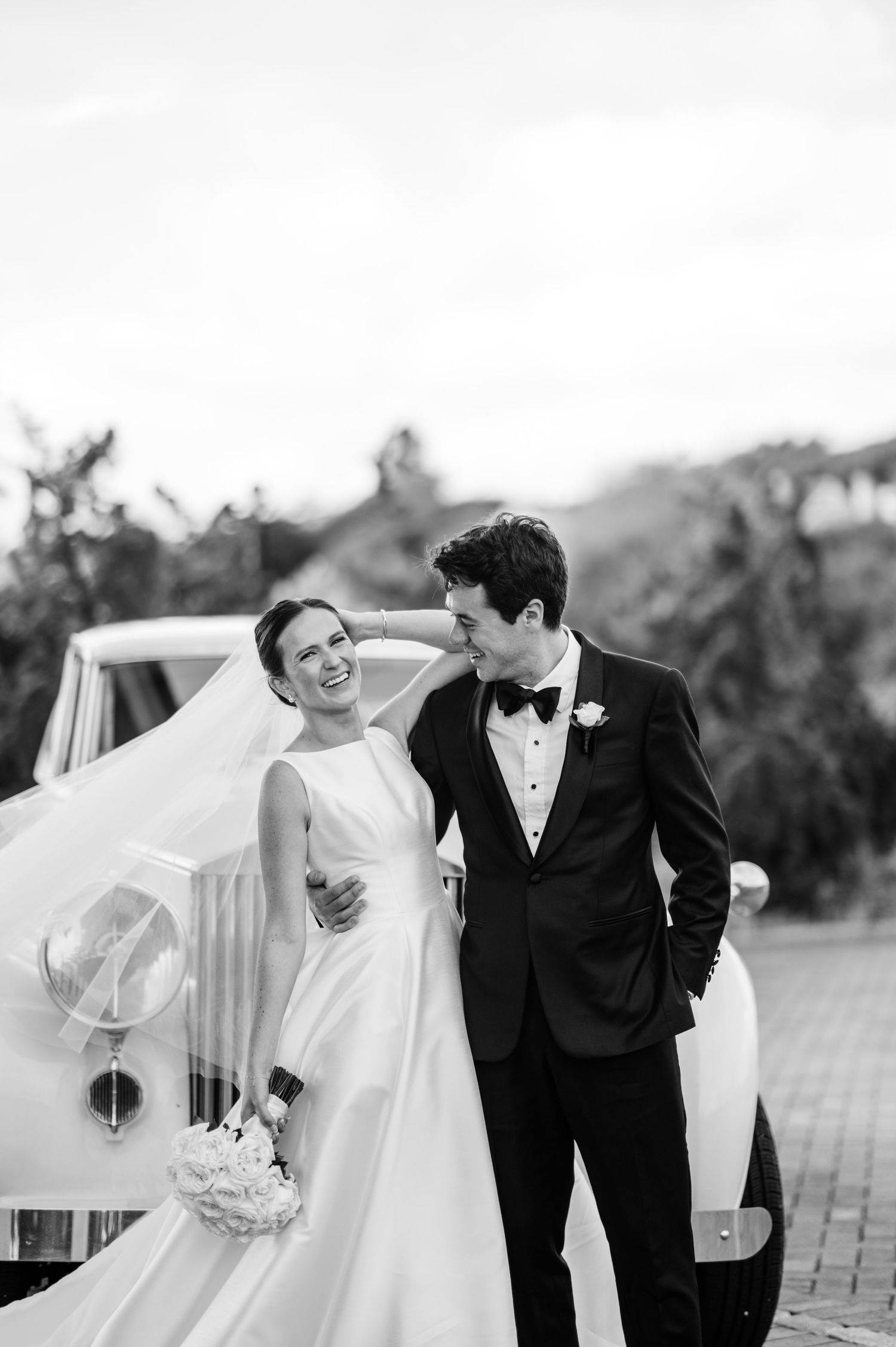 Wedding couple in formal attire walking together outdoors.