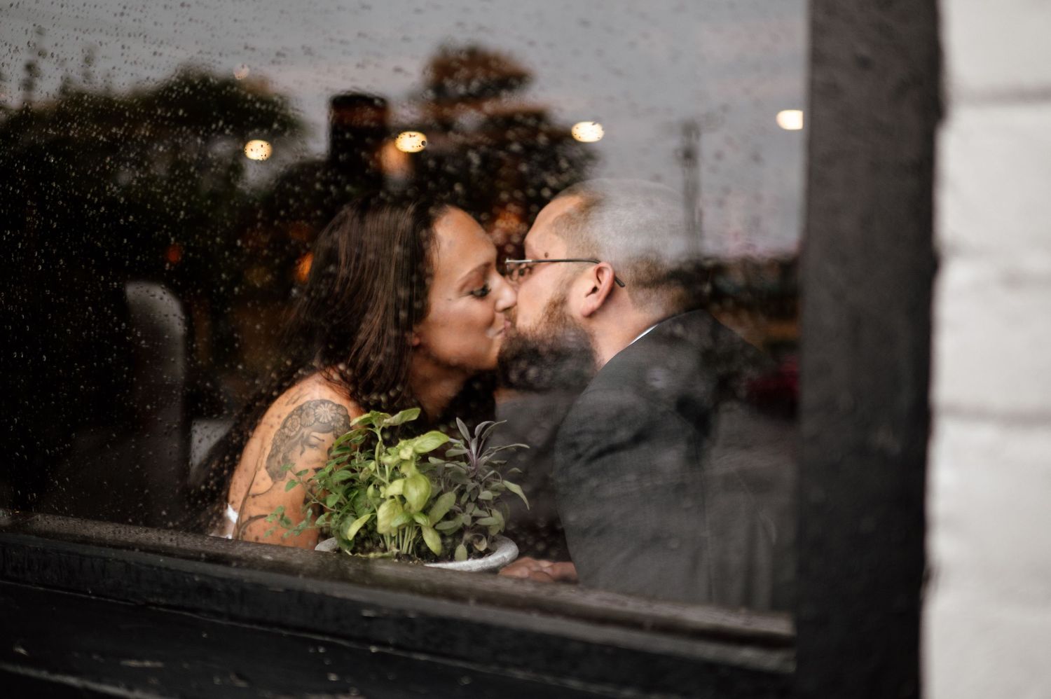 Intimate wedding portraits captured against an industrial brick wall background.