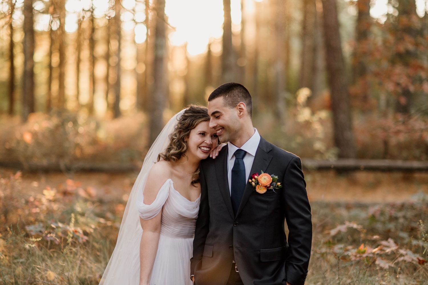 Romantic autumn wedding photos captured in a sunlit wooded area.