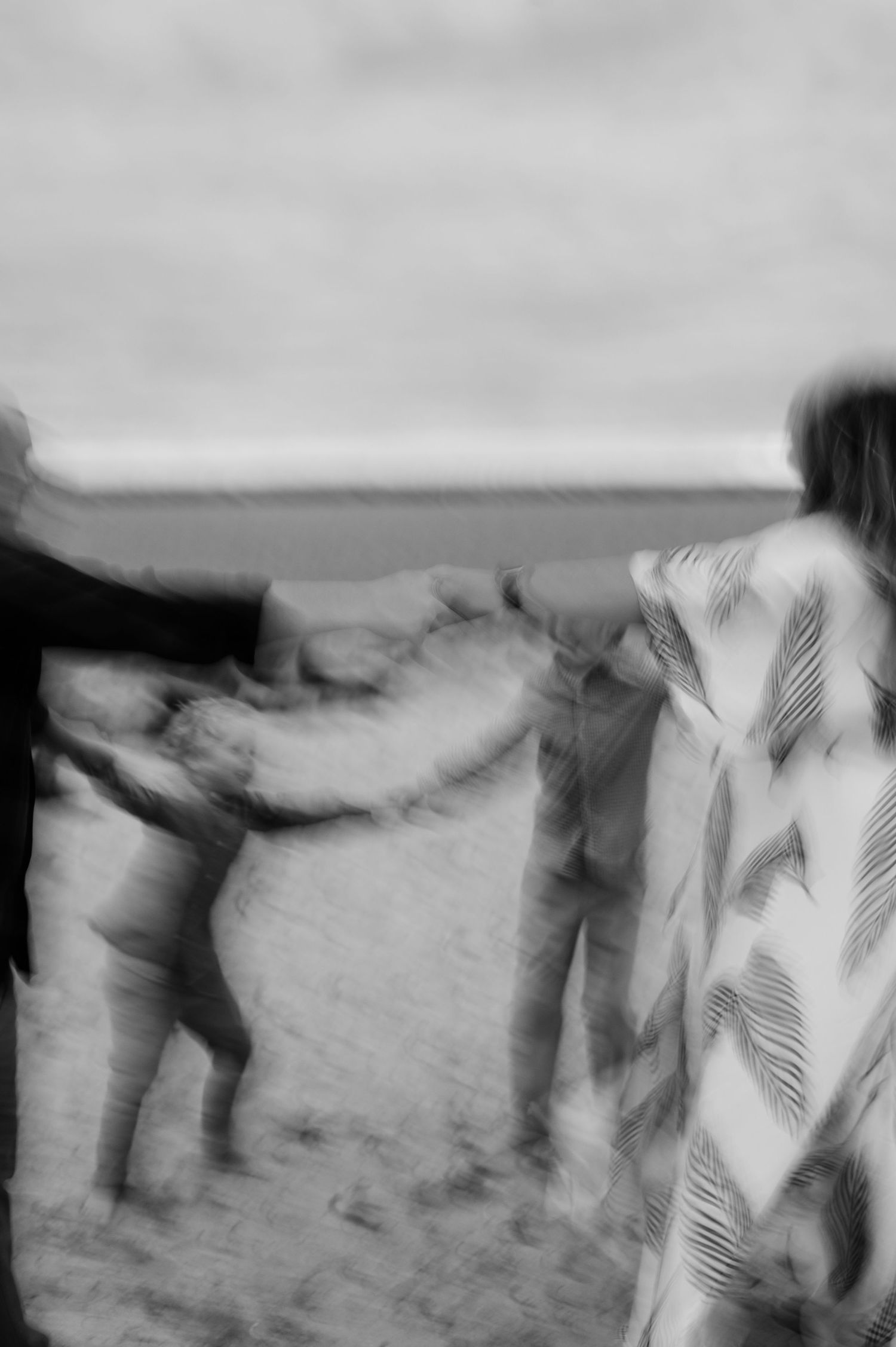 Abstract black and white motion blur of people walking on a beach.