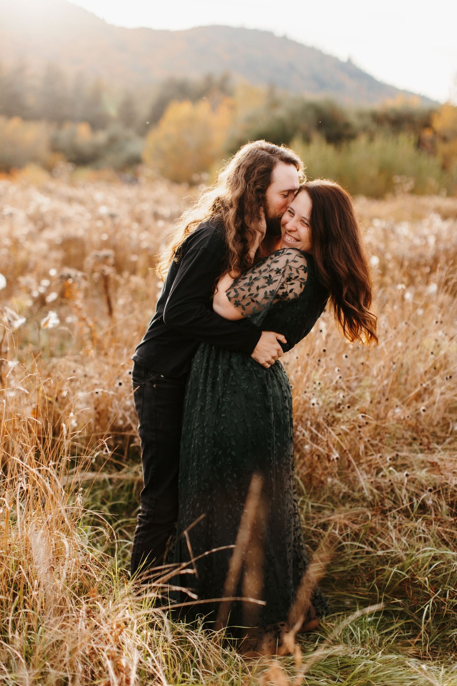 Couple sharing intimate moments in a golden autumn field at sunset.