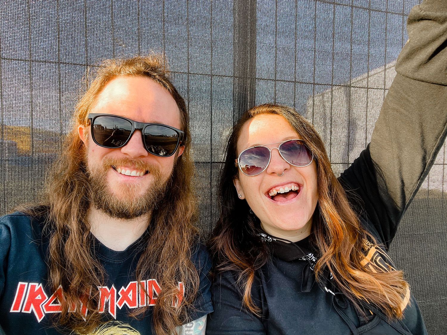 A group of people with long hair smiling and laughing together outdoors.