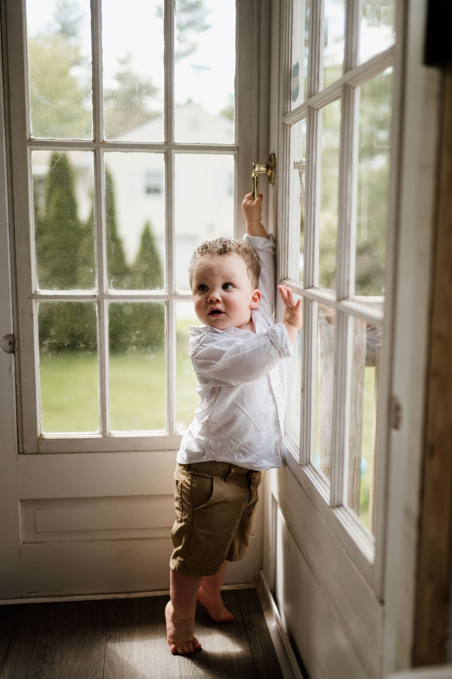 Sequence of photos showing a small child exploring and reaching up to a sunlit window.