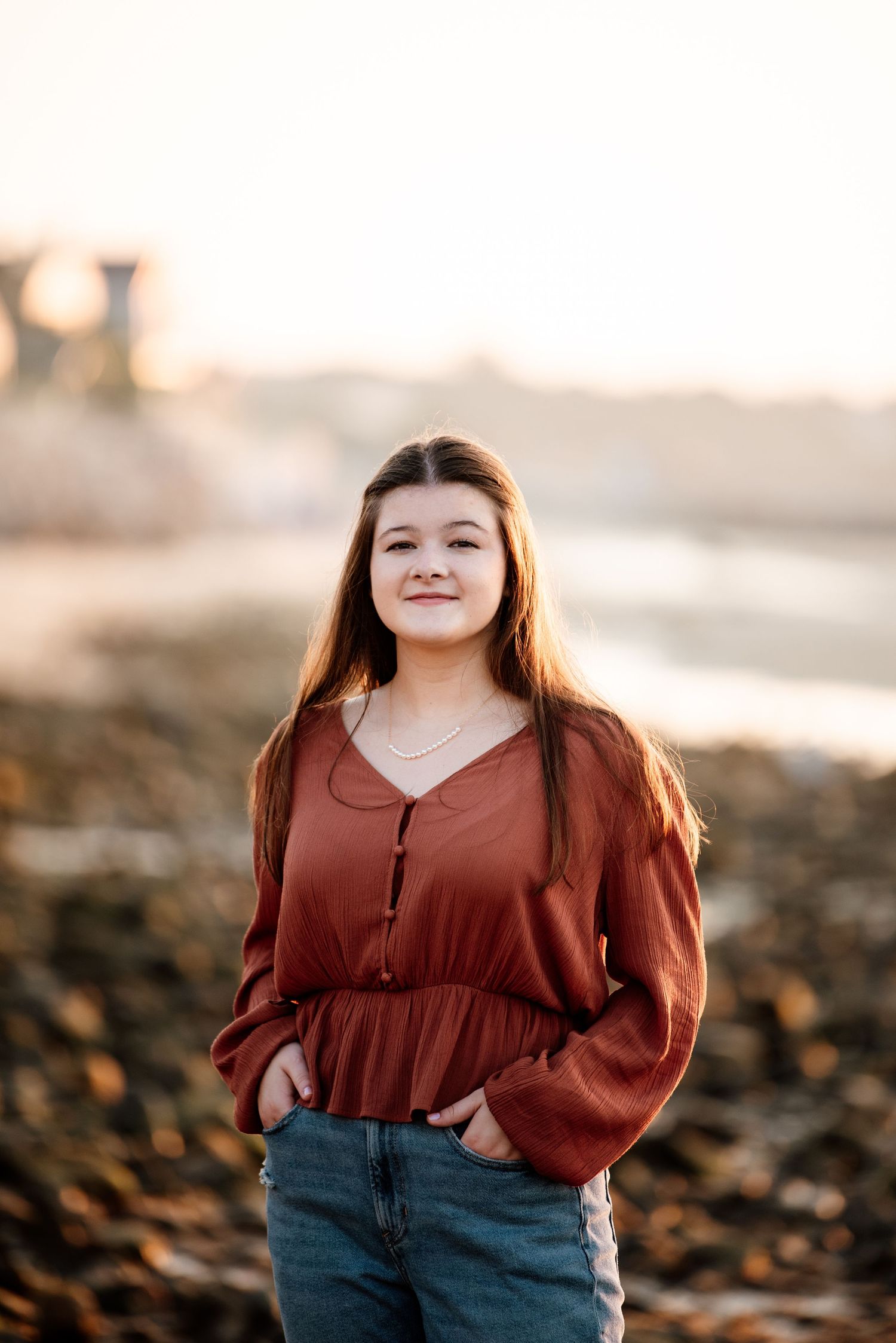 Sunset portrait series featuring rust-colored top and denim against warm lighting.