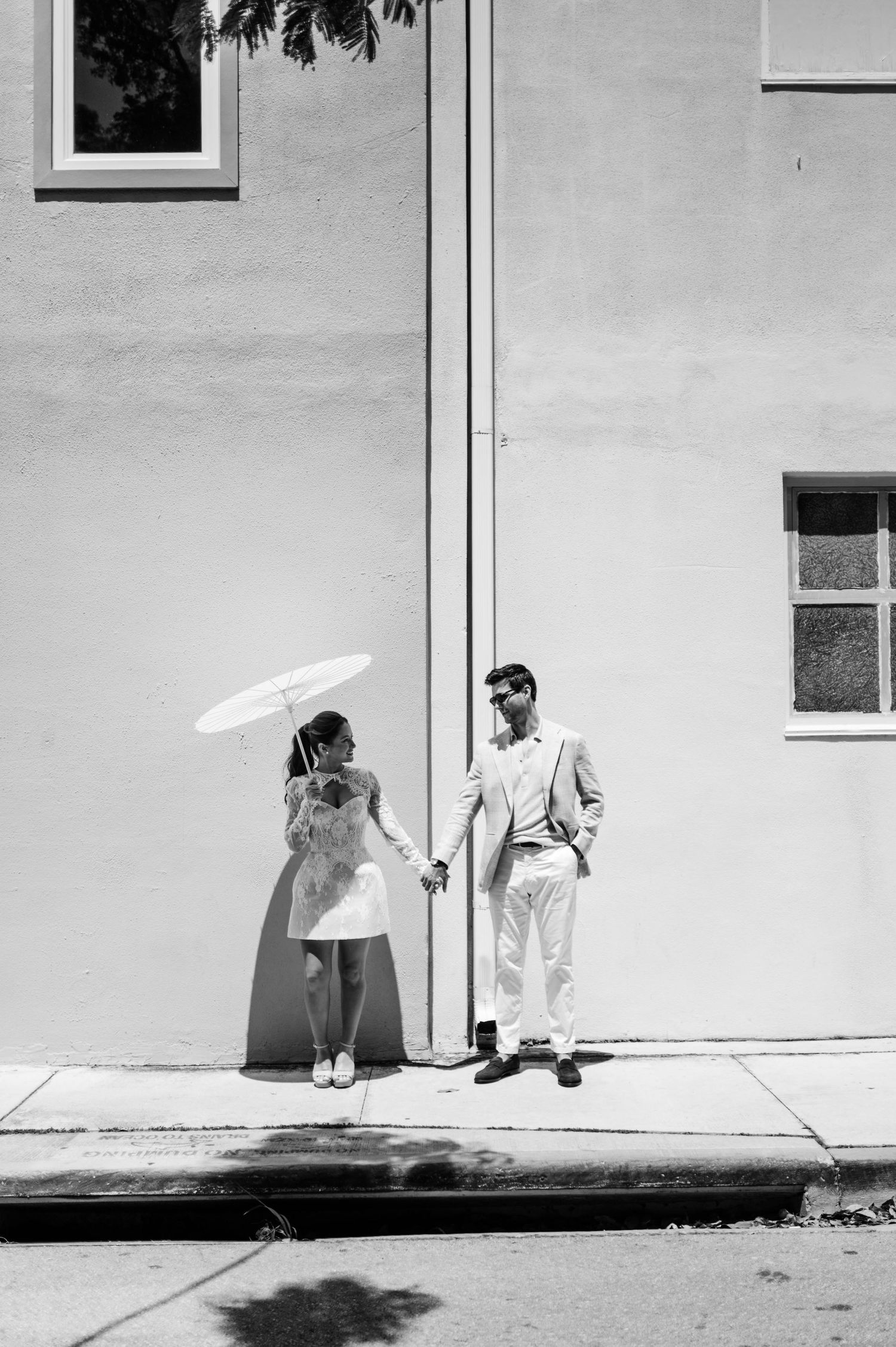 Artistic black and white photo sequence showing playful shadows and interactions against a white wall.