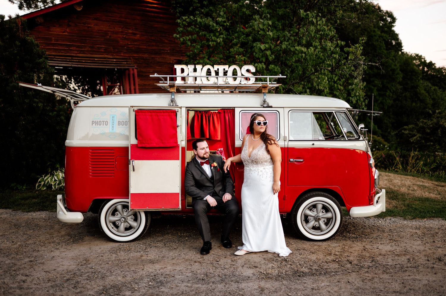 Classic red and white vintage VW bus serves as wedding photo backdrop.
