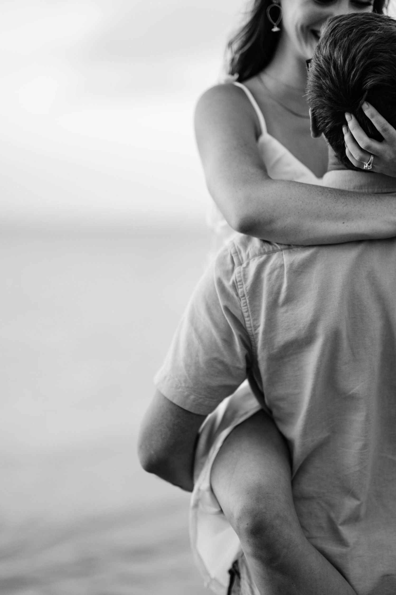 Intimate black and white portrait of a couple embracing in a tender moment.