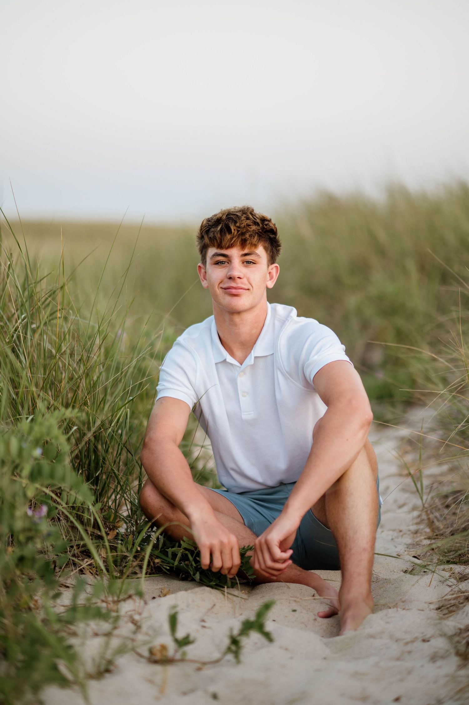 Portrait series at a sandy beach with tall grass during golden hour, showing casual outdoor poses.