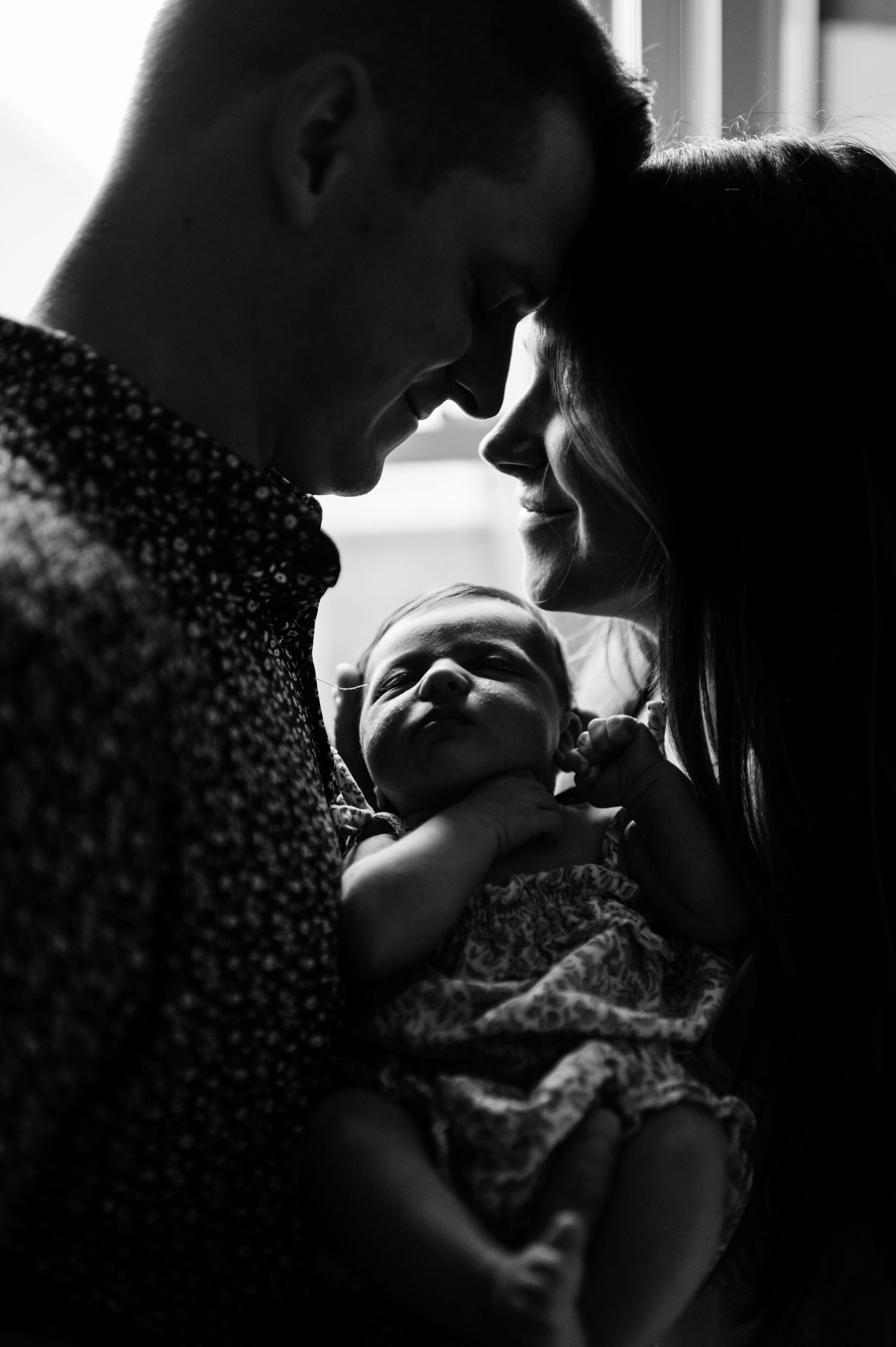 Intimate black and white close-up portraits capture tender moments between a couple in soft lighting.