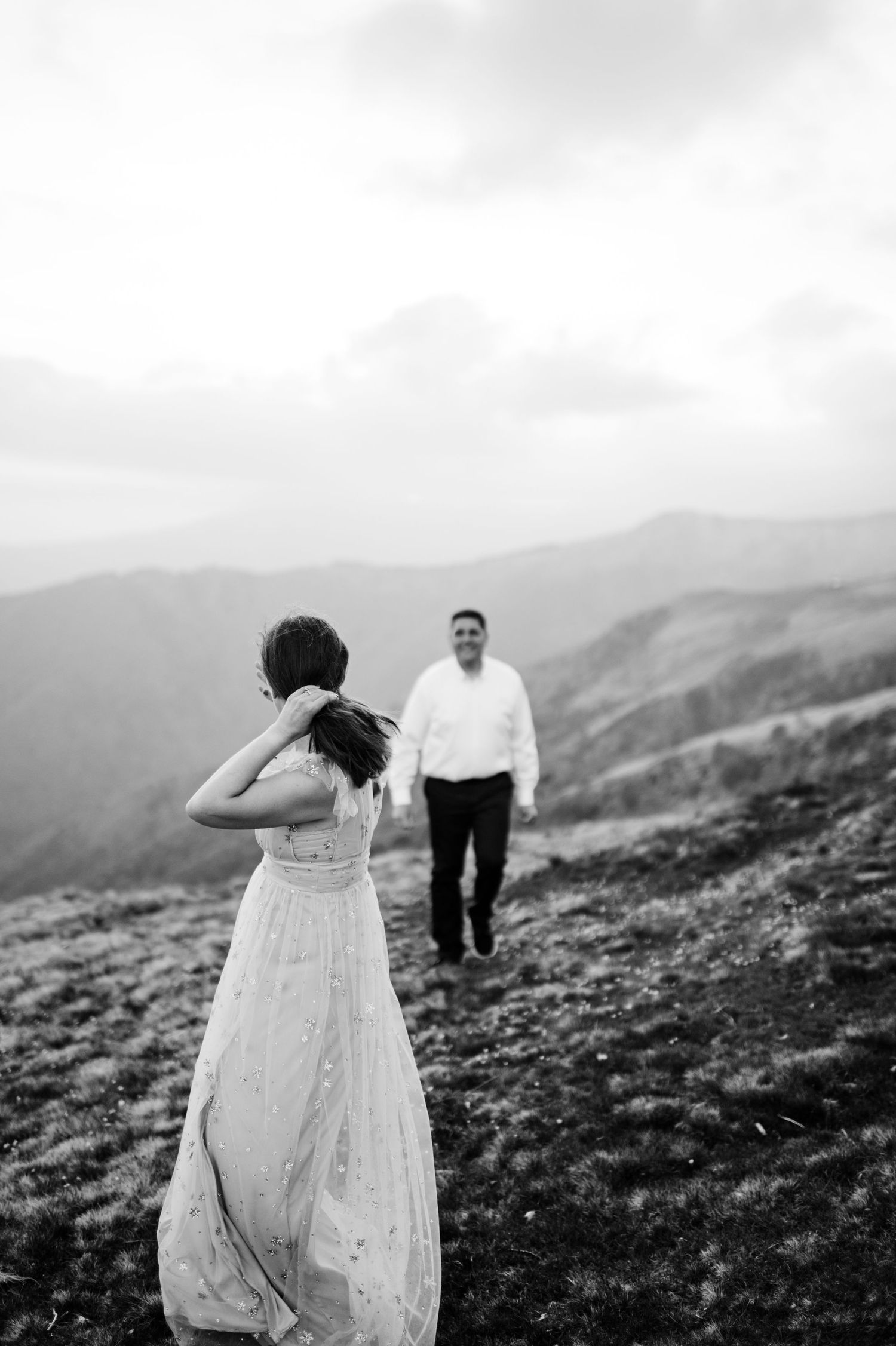 A black and white wedding photo sequence shows a couple walking together on a scenic mountain ridge.