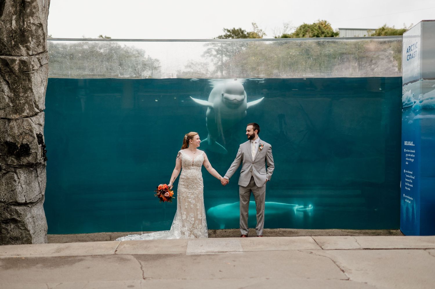 Wedding party posing for creative underwater-style photos in front of a blue backdrop.