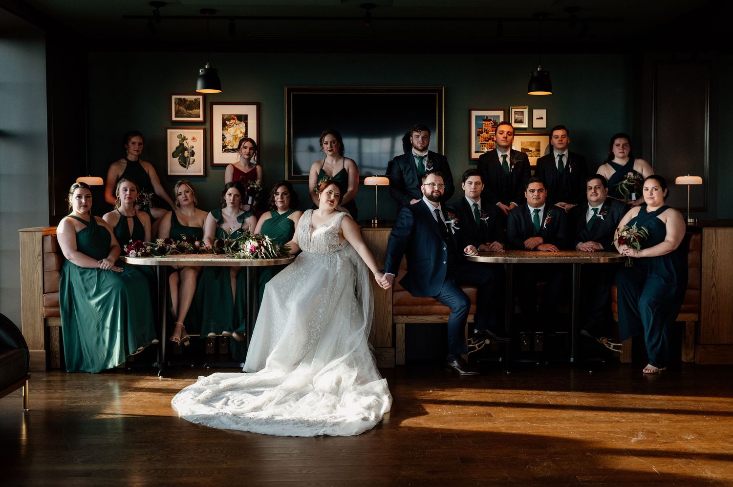 Wedding reception venue with dark walls and guests seated along the perimeter.