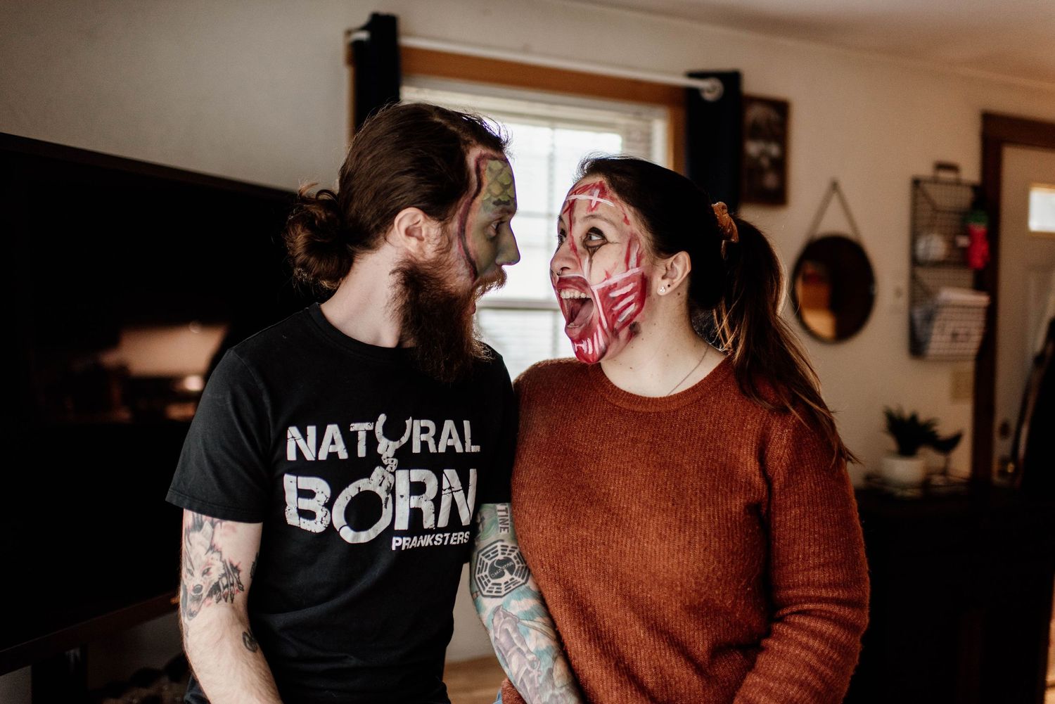 A couple in casual attire sharing an intimate moment in a dimly lit room with natural window light.
