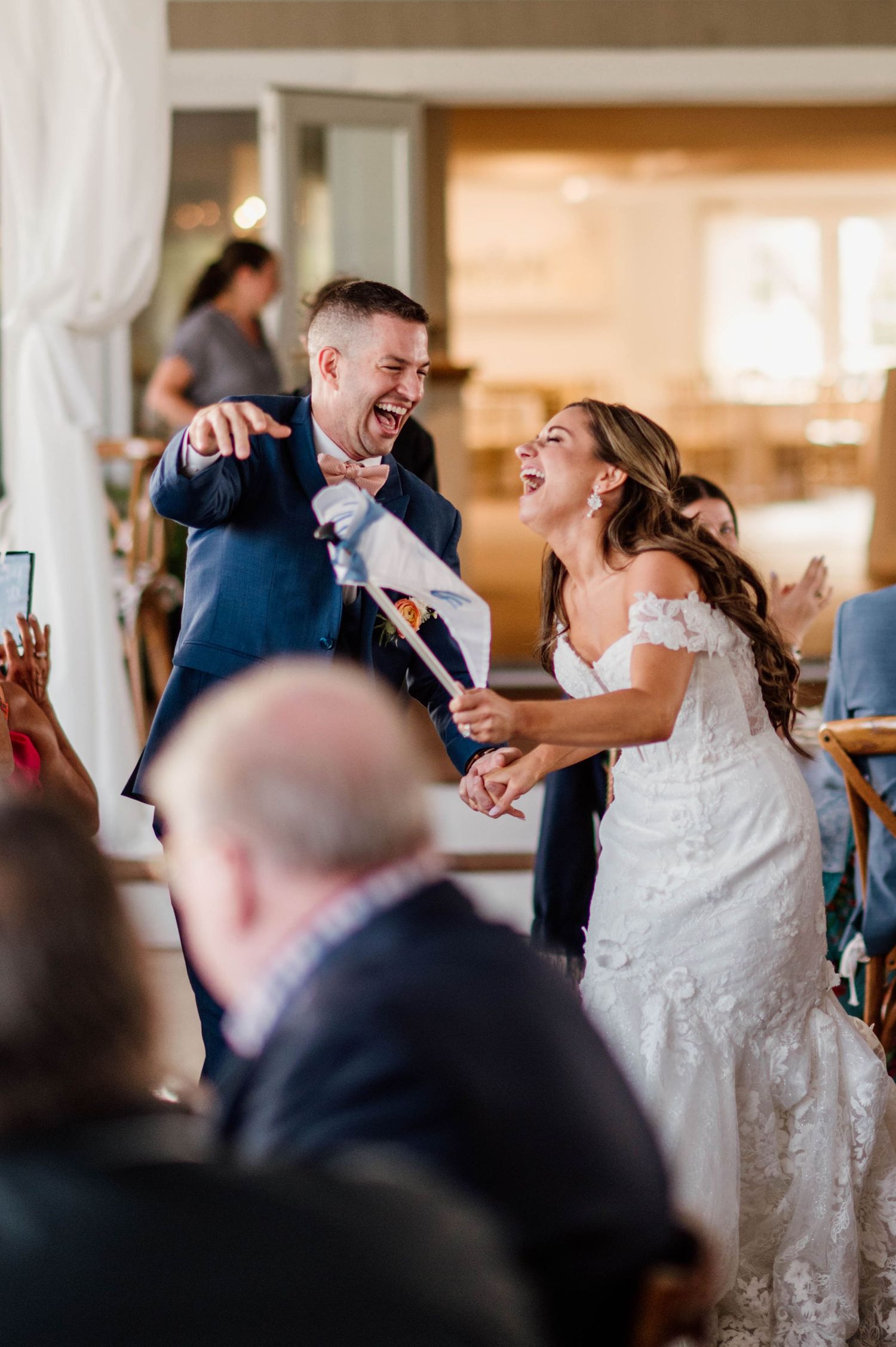A couple shares a joyful moment while dancing together at their wedding reception in an elegant indoor venue.