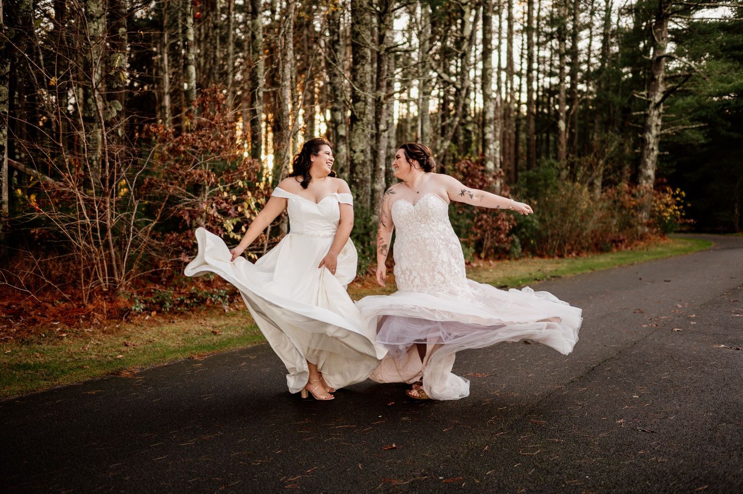 Wedding couple running and playing through a forest path with bride's dress flowing behind them.