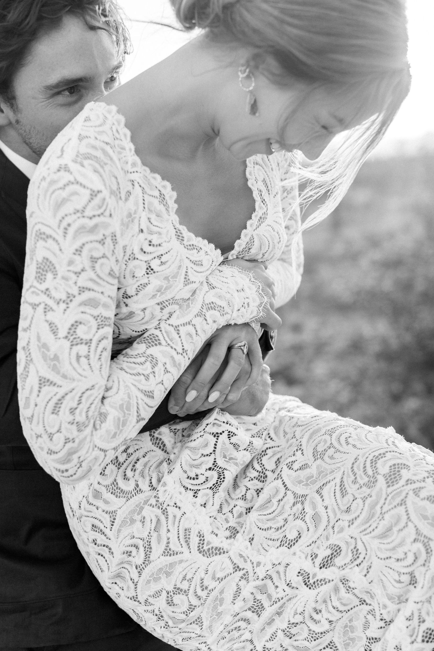 Close-up details of intricate white lace wedding dress with delicate patterns.