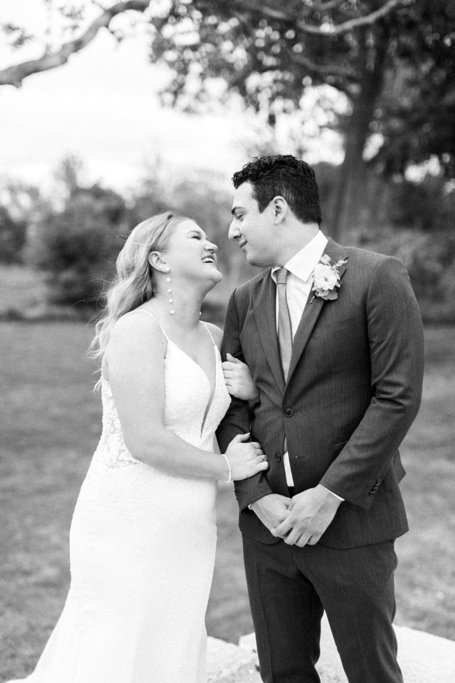 Black and white wedding portrait showing natural laughter between the couple.